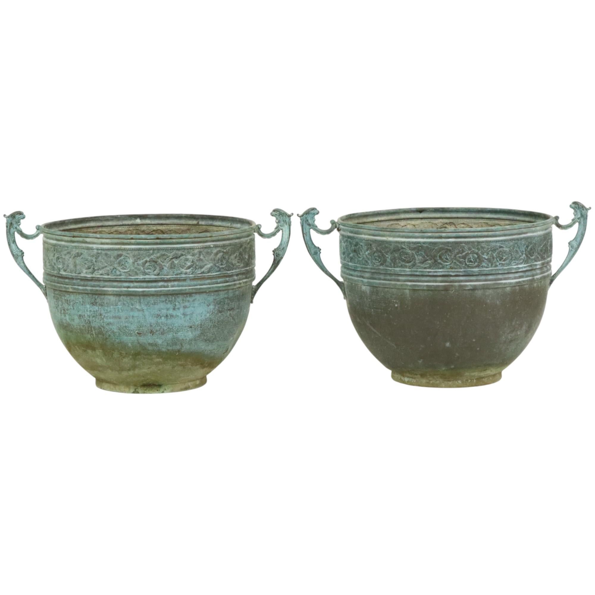 Rare paire de pots de fleurs ou vases de jardin en cuivre jaune (laiton) repoussé oxydé, entièrement dans le style classique de l'Art Nouveau, décorés d'un motif floral sur tout le pourtour. Deux poignées sont en forme de gargouille ou de griffon.