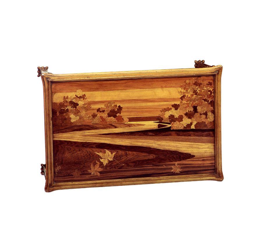 Indulgence in fine hand-carved detailing and a striking inlaid motif adorning the top distill this coffee table's exceptional cabinetmaking value. An impeccable reproduction of an original French Art Nouveau design by Emile Gallè, it is fashioned of