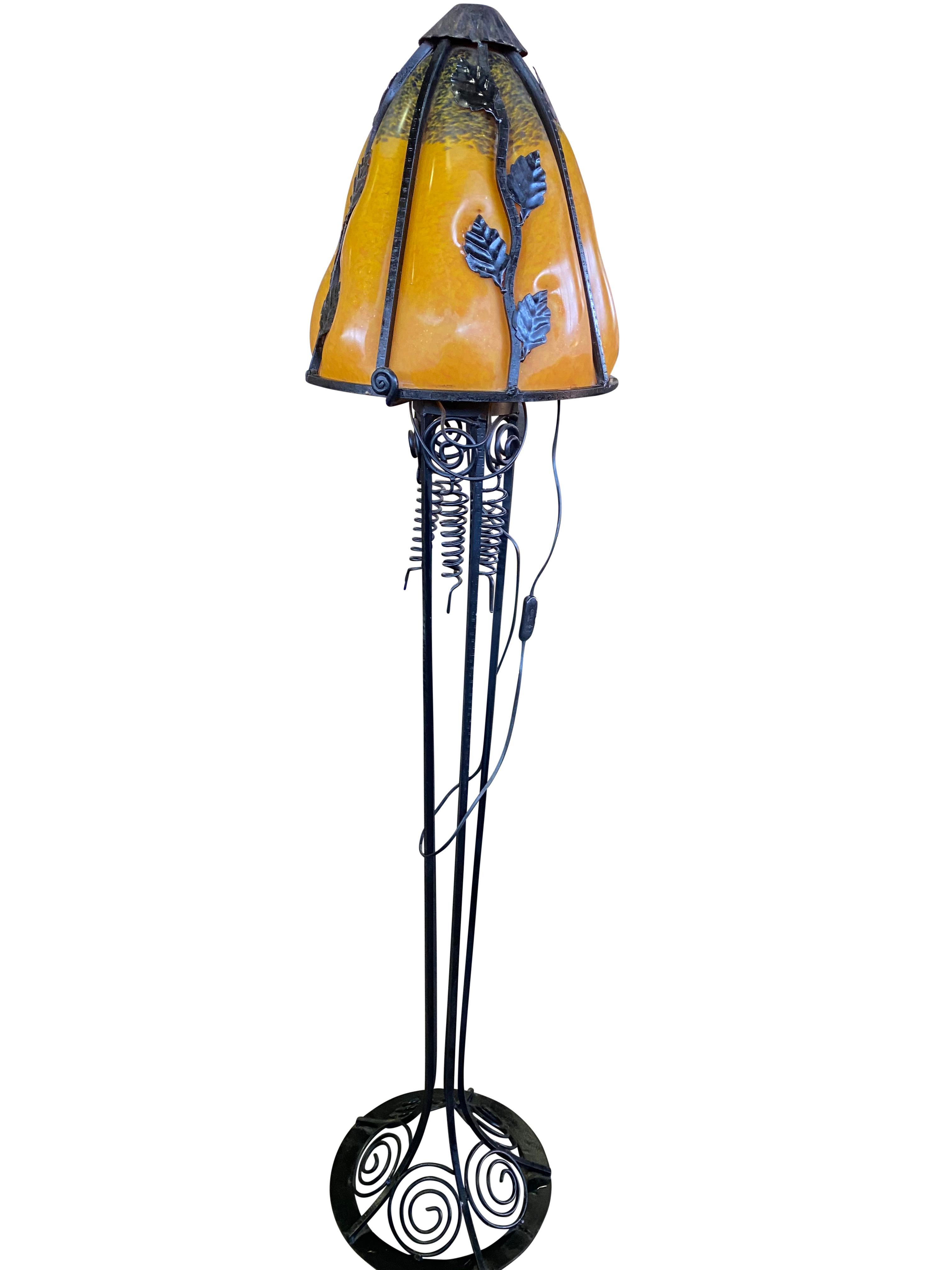 A wonderful French Art Nouveau style standard lamp, 20th century. The stands are handmade in wrought iron with black finish patina and hammered with floral pattern. The metalwork is of excellent quality.
Crowned with bright colored shades in