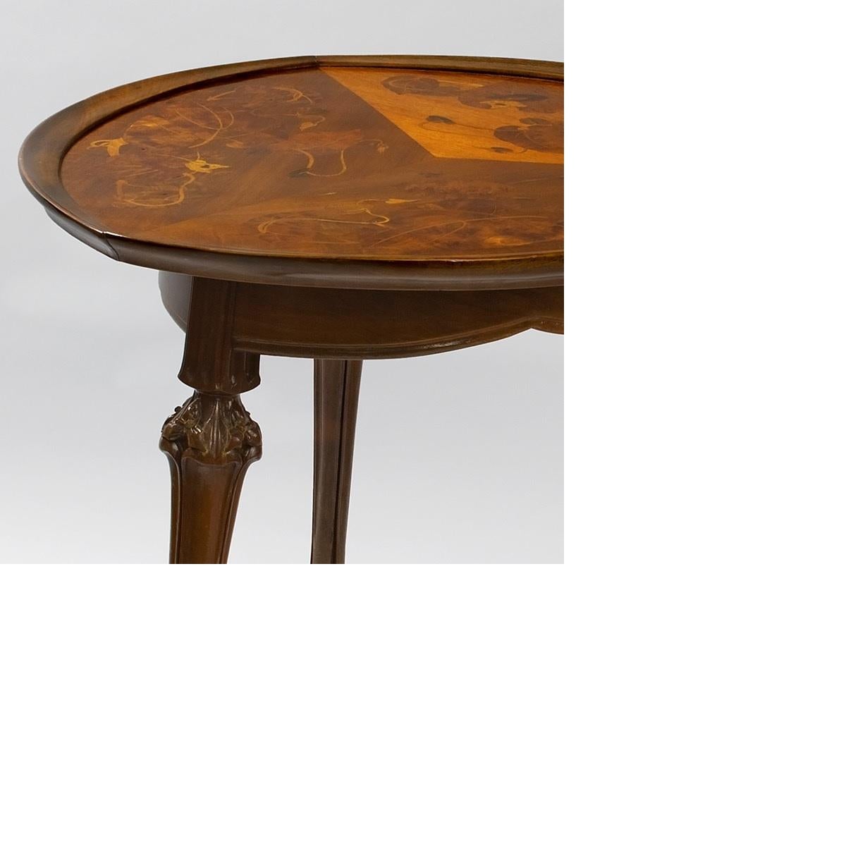 A French Art Nouveau mahogany salon table with fruitwood marquetry by Louis Majorelle. The table top is decorated with leaves and vines. The legs have carved flowers, circa 1900.

Provenance
Property from the Geyer Collection
Louis C. Tiffany