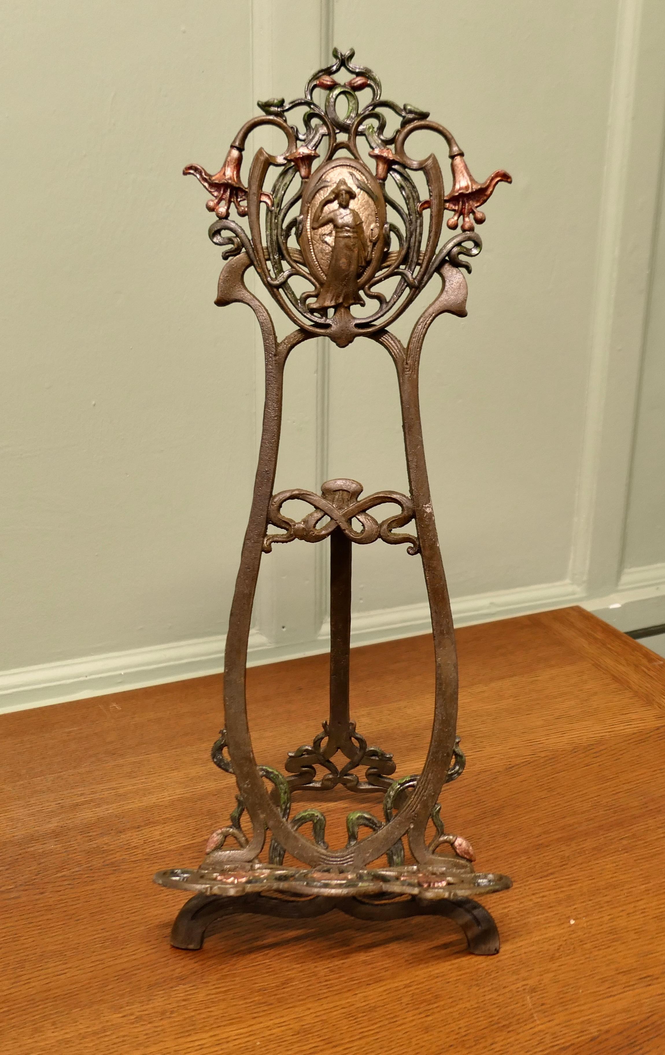 French Art Nouveau Table Easel or Book Rest 

This is a very attractive piece it is made in iron and has decorative detail on the top of Marianne and at the bottom of the stand with stylised flowers and is highlighted with verdigris and copper paint