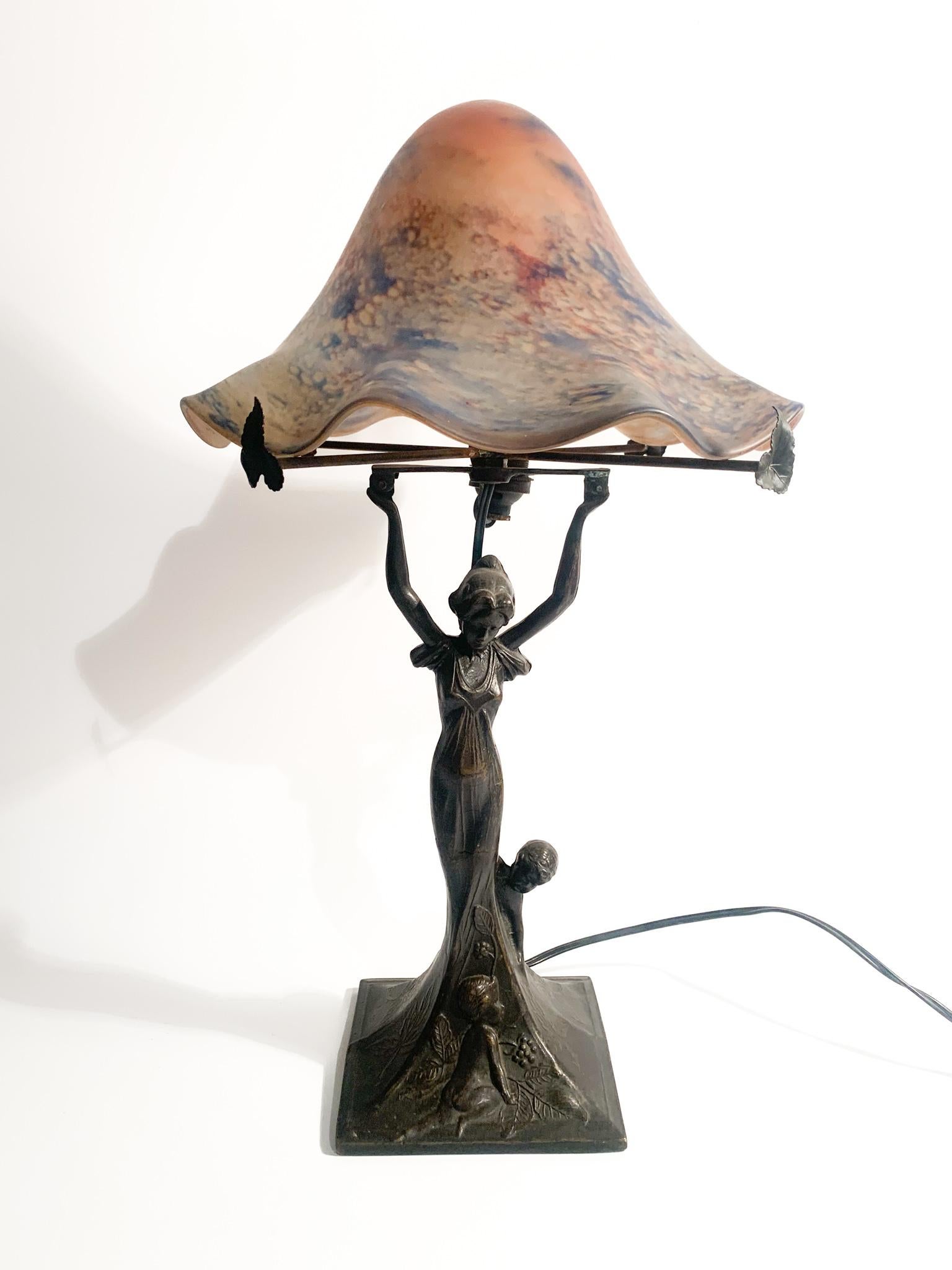 Liberty table lamp, with bronze base and pink and purple glass cap, made in France in the early 20th century. The lamp cap has a slight chip, as shown in the photos. Additional information is available upon request.

Ø 24 cm h 44 cm