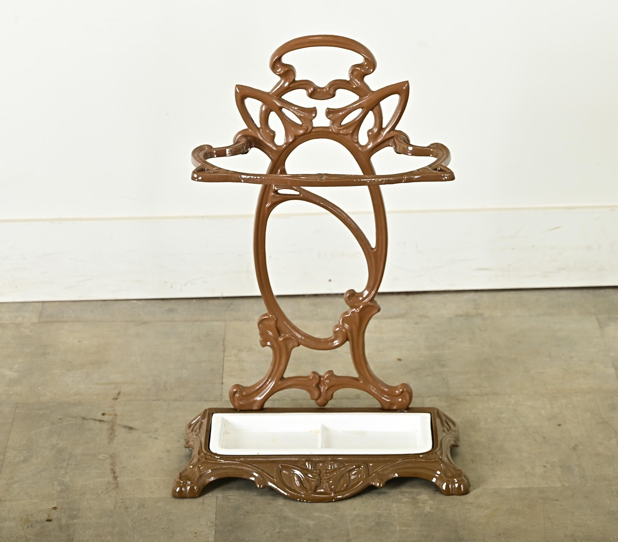 Un portaombrelli scultoreo in stile Art Nouveau francese di fine secolo (circa 1900), realizzato in ghisa smaltata in marrone lucido. Le viti stilizzate e tortuose formano il profilo della cresta e l'anello di supporto della struttura metallica,