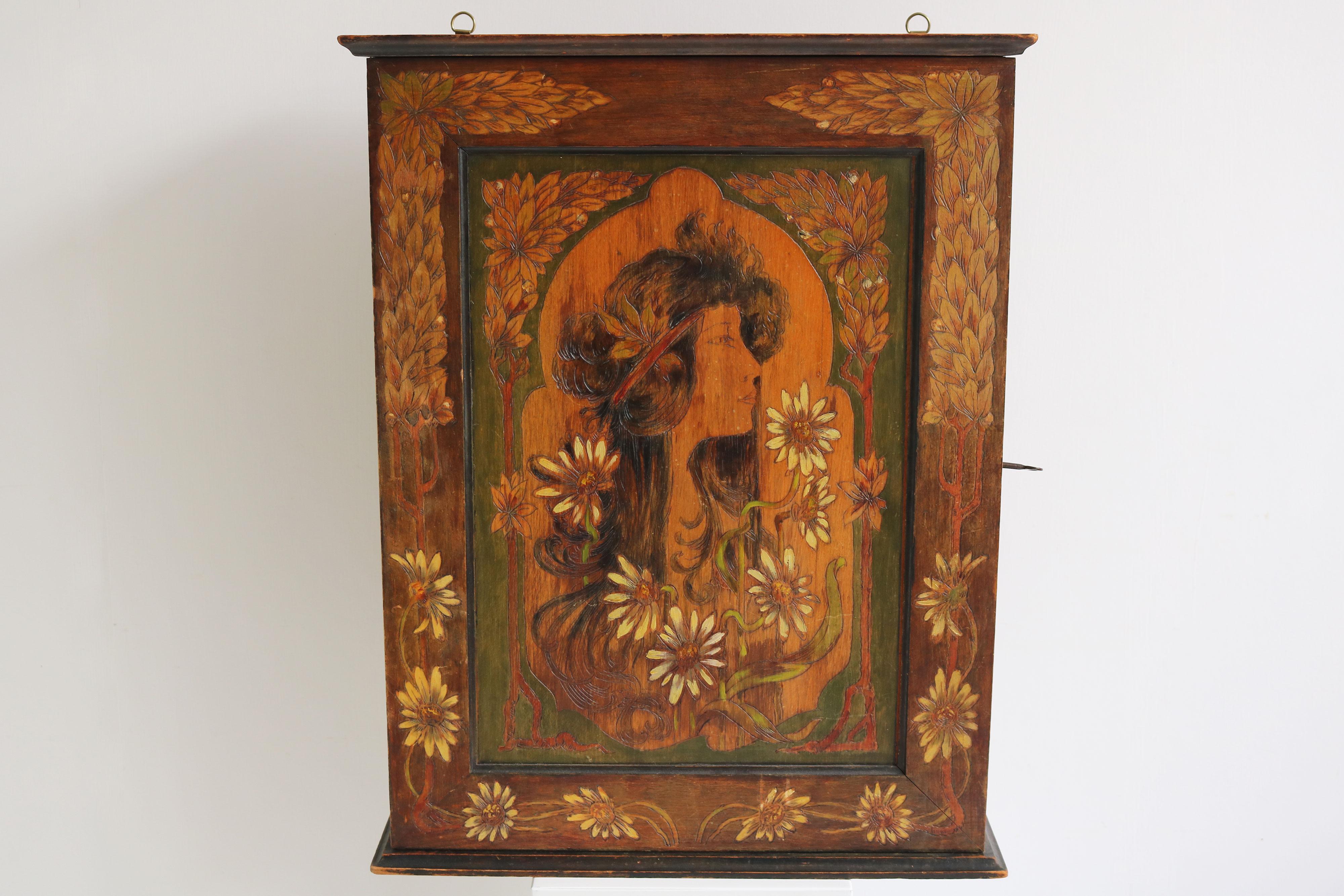 Gorgeous French Art Nouveau Wall cabinet / hanging cabinet in the style of Alphonse Mucha 1900. 
The piece has been carved and hand painted on all 3 sides displaying a work in the similar style of Alphonse Mucha 
It has not been signed but we are