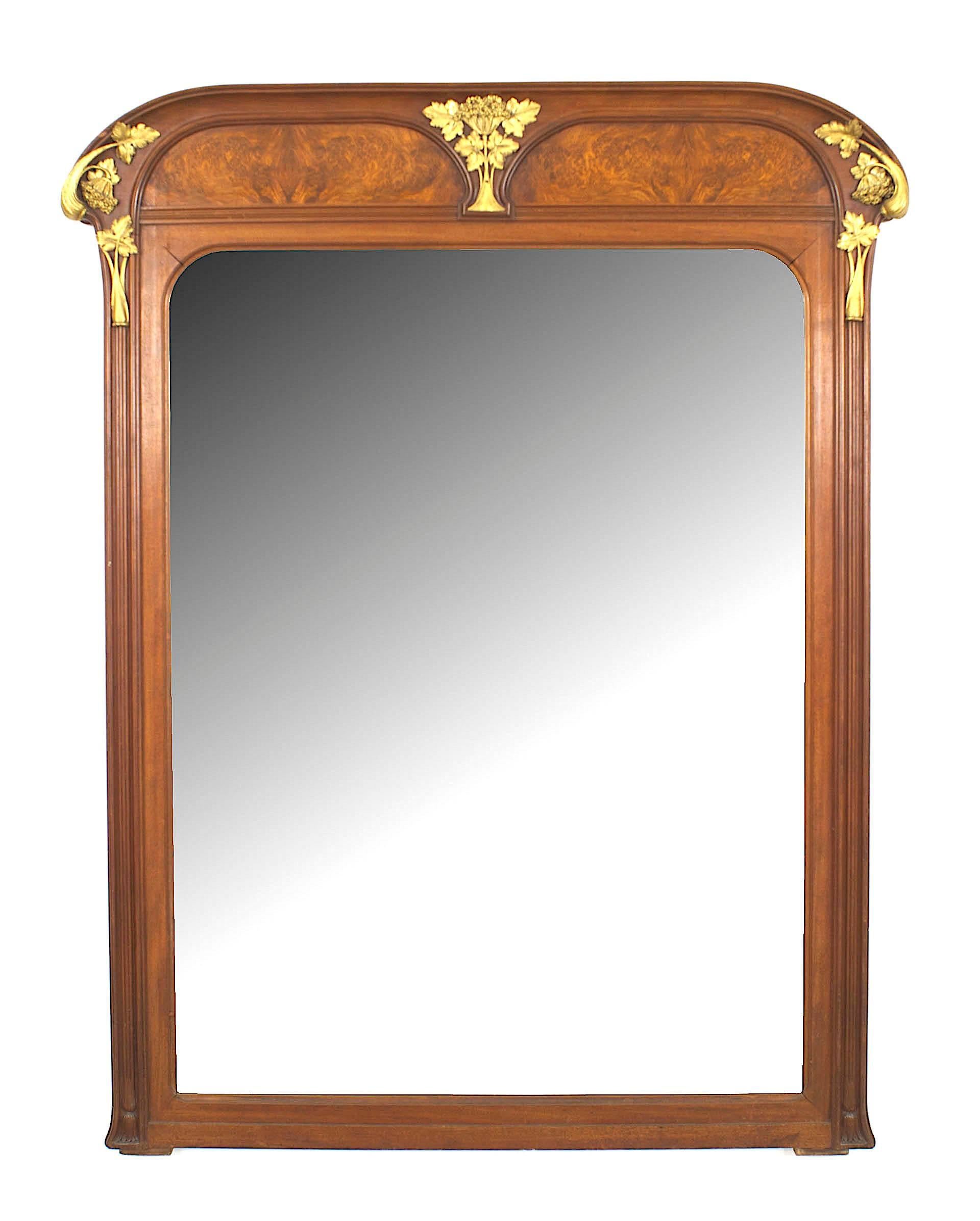 French Art Nouveau walnut wall mirror with a beveled glass, two burl walnut top panels, and floral motif gilt bronze trim. (by LOUIS MAJORELLE)
