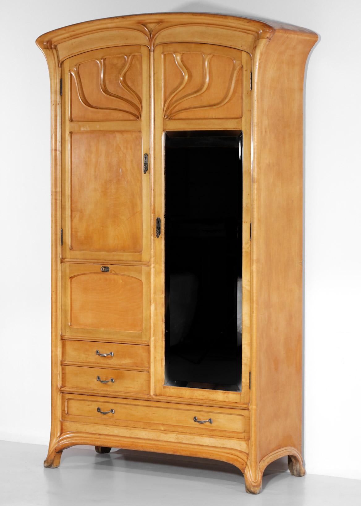 Superb French armoire from the art nouveau period of the 1920's in the style of Henry Van De Velde's work. Solid wood and veneer structure, it is composed of two hinged doors, one of which with a full height mirror, opening on a panderie on the