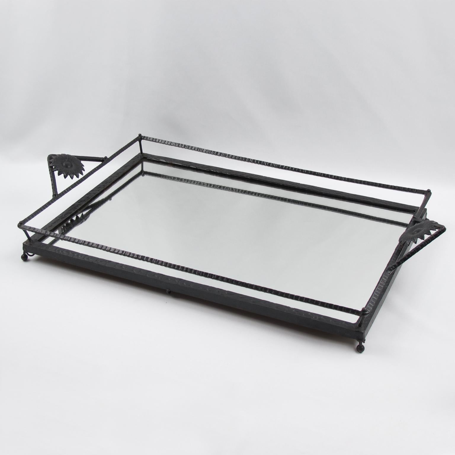 Impressive large Art Nouveau serving tray, featuring wrought iron framing in black finish patina with hammered textured pattern. Very nice floral handles and mirrored glass insert. Large dimensions, perfect for barware, cocktail serving or any