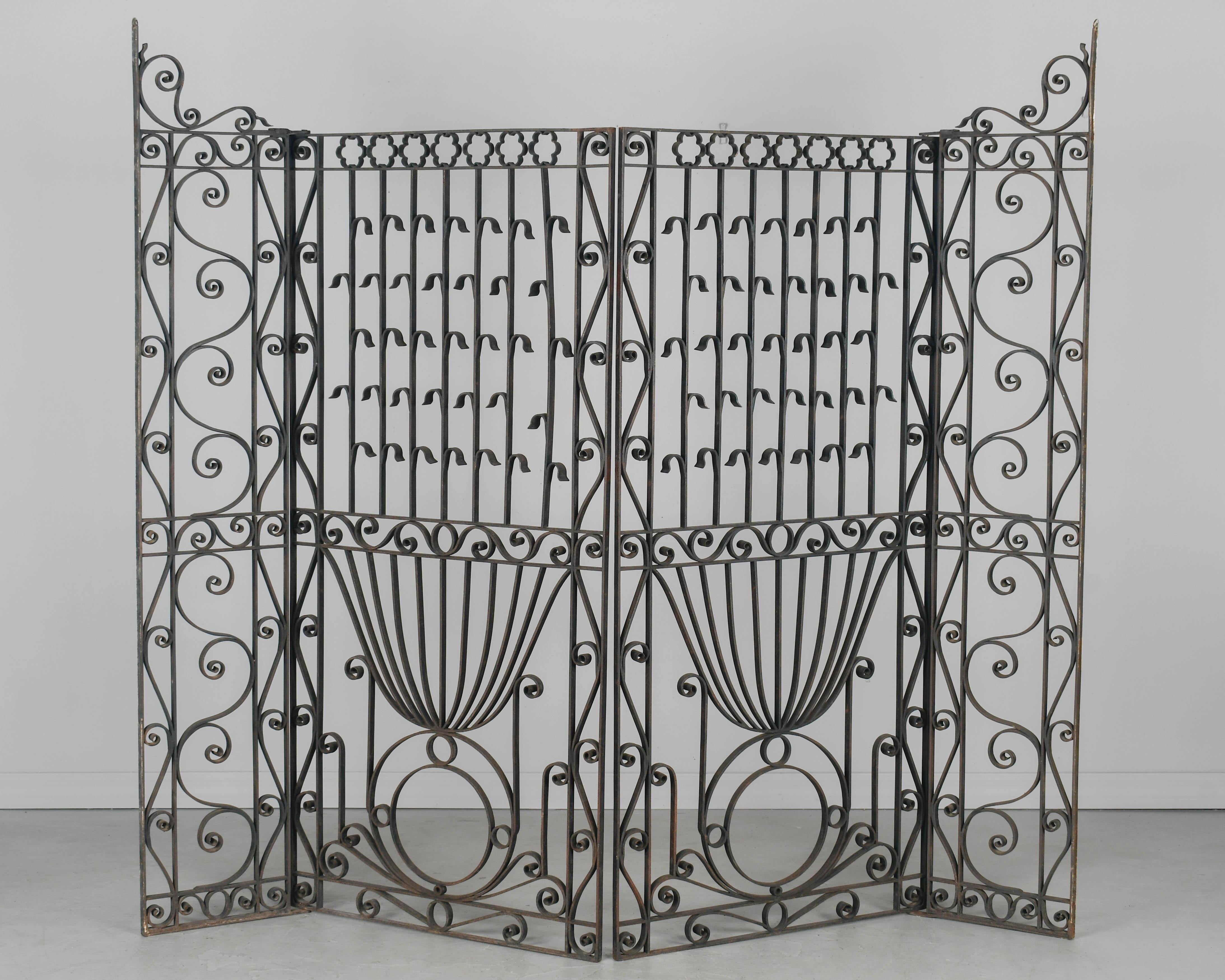 Grand portail en fer forgé de style Art nouveau français avec deux panneaux articulés : un panneau étroit avec des trous pour le fixer dans l'entrée de la porte, et de grands panneaux décoratifs qui s'ouvrent en pivotant. Travail du fer de bonne