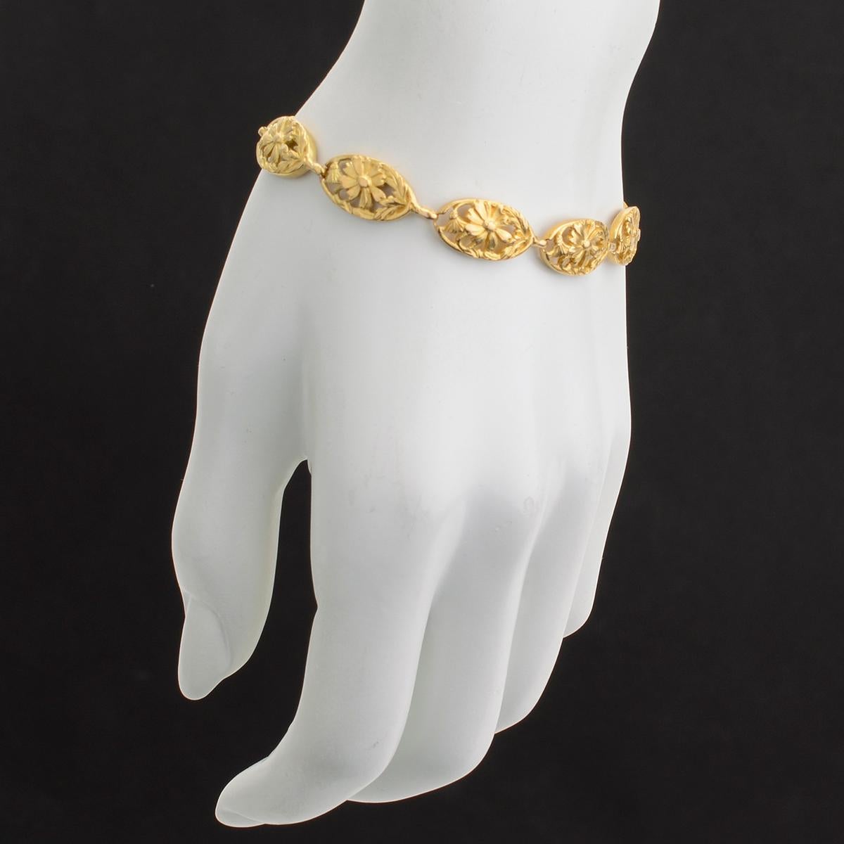 Oval-shaped link bracelet, with openwork floral motifs, in 18k yellow gold. Gold cable link safety chain. 7.5