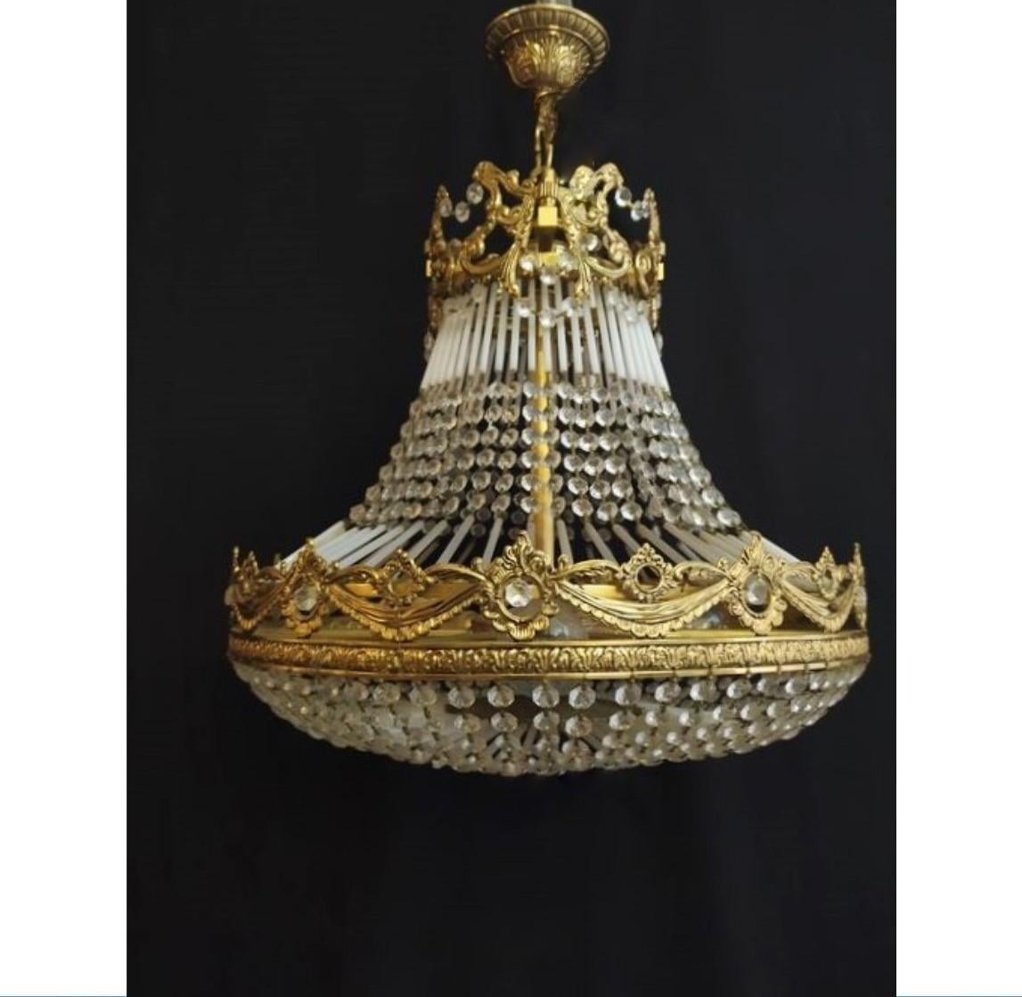 A wonderful Arte deco Period crystal and bronze chandelier, with glass rods connectiting the crystal chains, France, 1930s. The chandelier is in very good vintage condition, beautiful aged patina to bronze, crystals and glass rods complete, cleaned