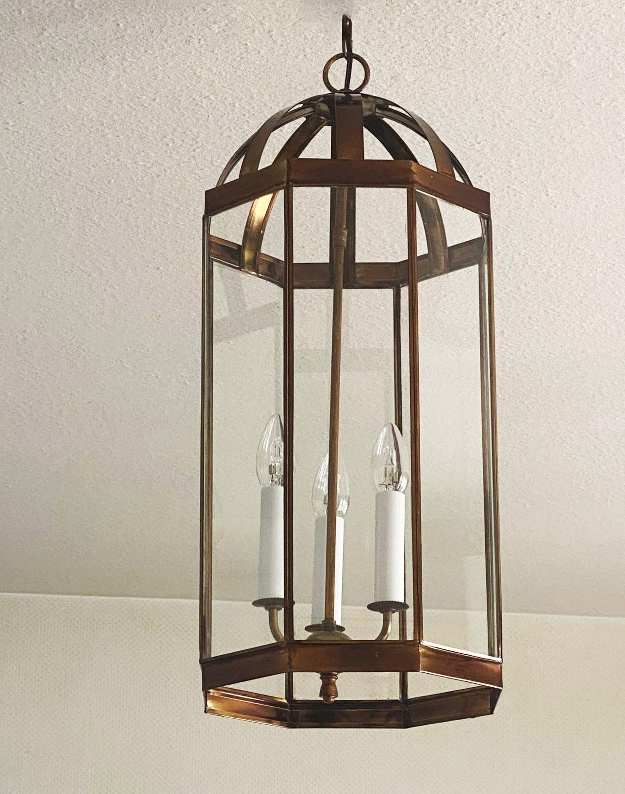 Elegant, tall Arte Deco patinated brass and glass eight-sided lantern, France late 1930s, with a central three-light candelabra cluster and eight clear glass panels. The lantern is in its original condition, no damages, rewired, arrives with 31