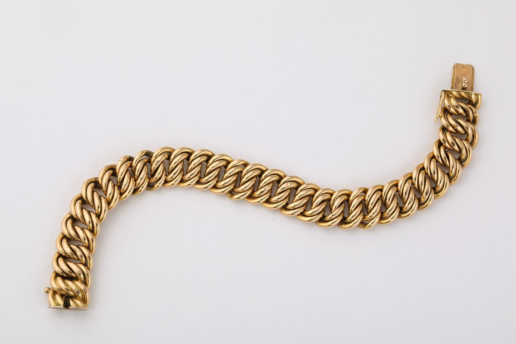 Cet élégant bracelet français présente un design articulé intemporel, réalisé en riche or 18 carats. Les maillons sont savamment tissés en un motif entrelacé, créant une texture fluide et sophistiquée qui se drape magnifiquement sur le poignet.