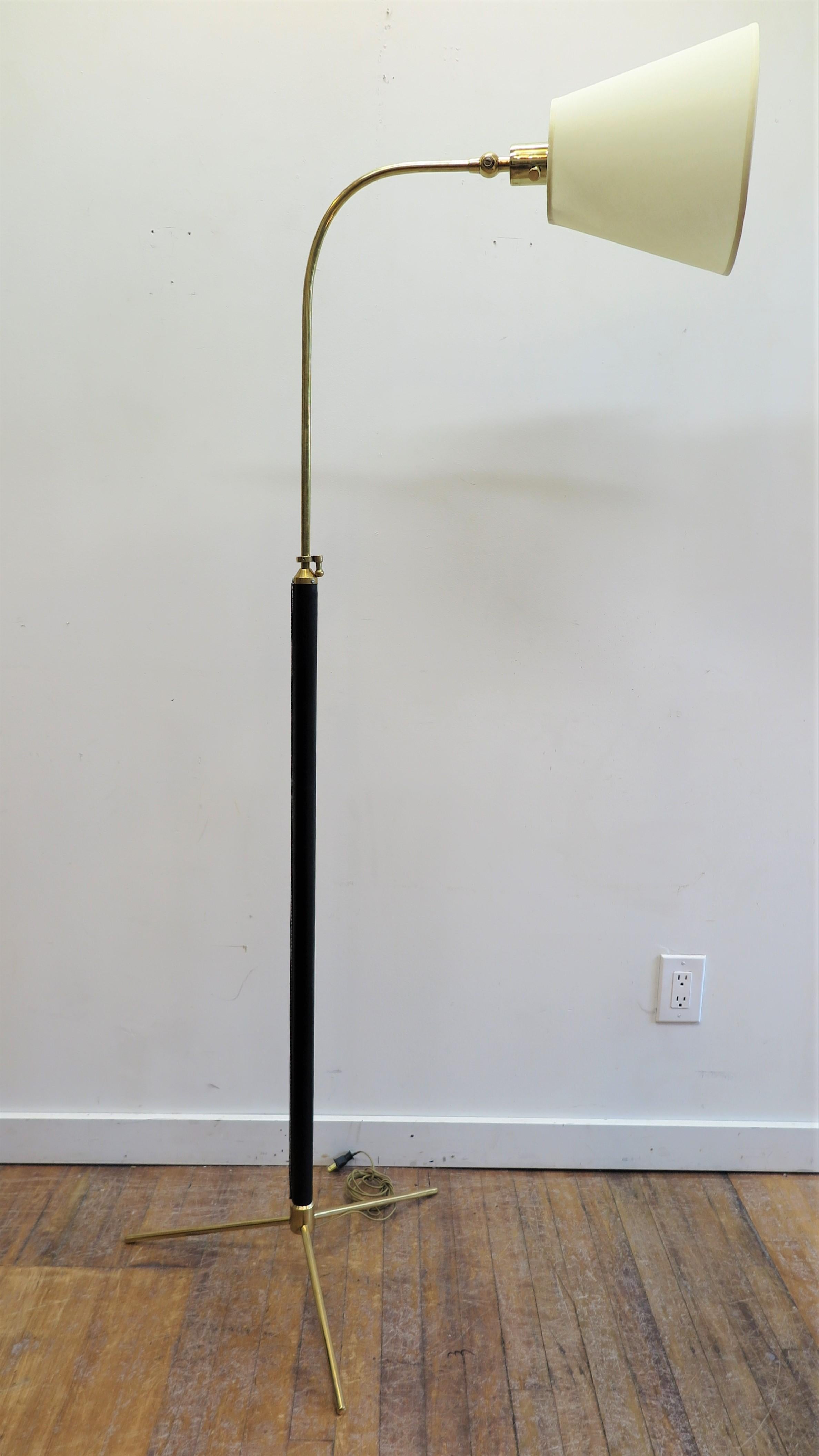 Mid century brass and leather wrapped articulating floor Lamp attributed to Jacques Adnet. A stunning floor lamp with height adjustment, 360 turning radius, articulating lamp allowing for up to down motion operating with dimmer switch on the socket.