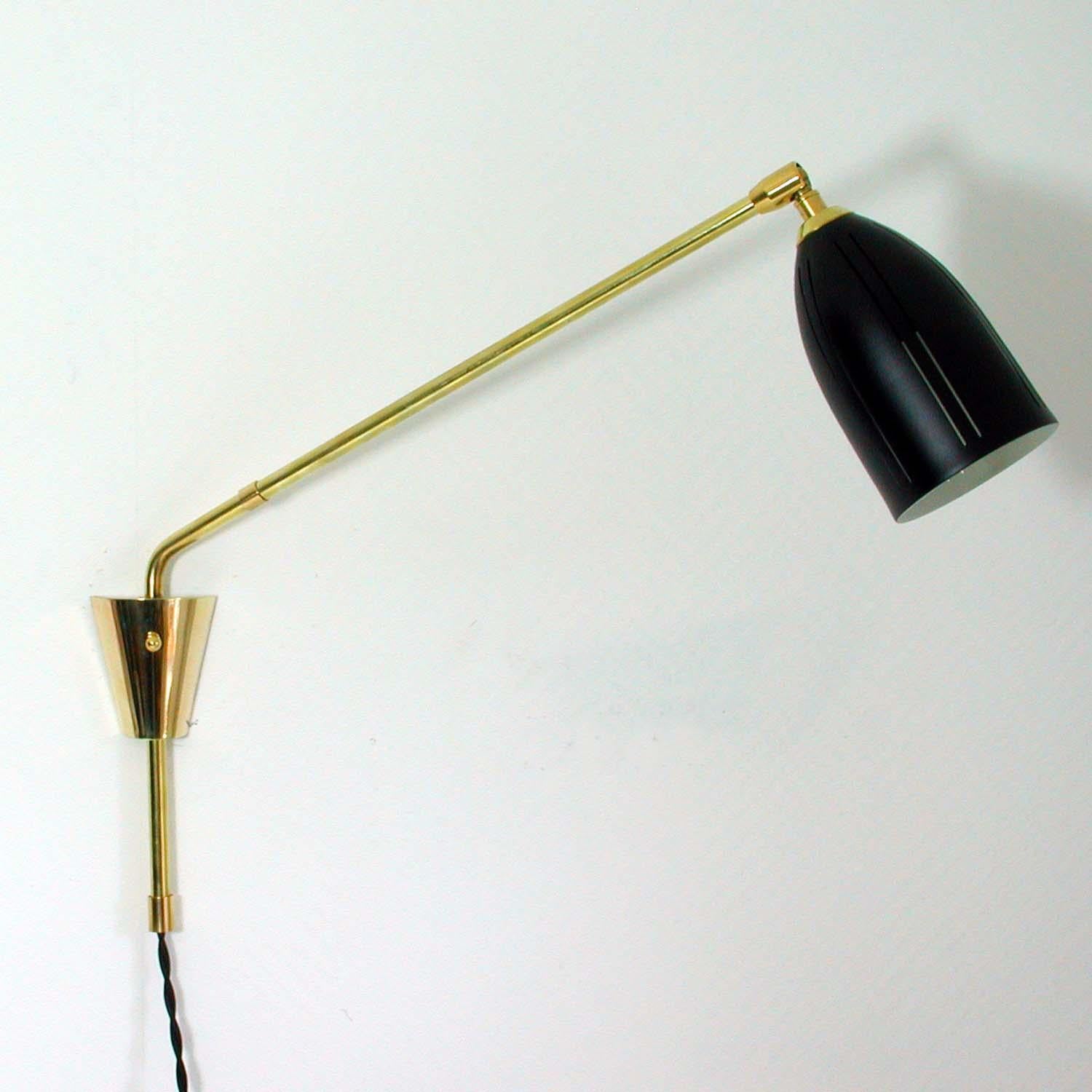 Awesome swivelling French wall lamp with adjustable shade. The lamp has got a lampshade made of black lacquered metal. The swivelling lamp arm is made of brass.

The lamp has been rewired for use in US and has got an E27 Edison screw on socket and