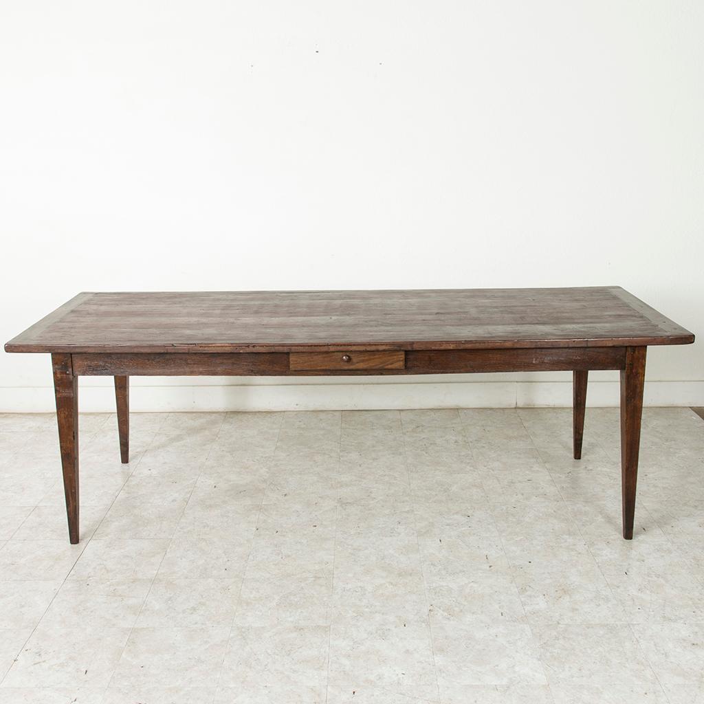 This turn of the 20th century artisan-made farm table is from the region of Le Perche, a Sub-region of Normandy, France. Its poplar top is constructed using mortise and tenon joinery and measure 93.5 inches long and nearly 38 inches wide. Resting on