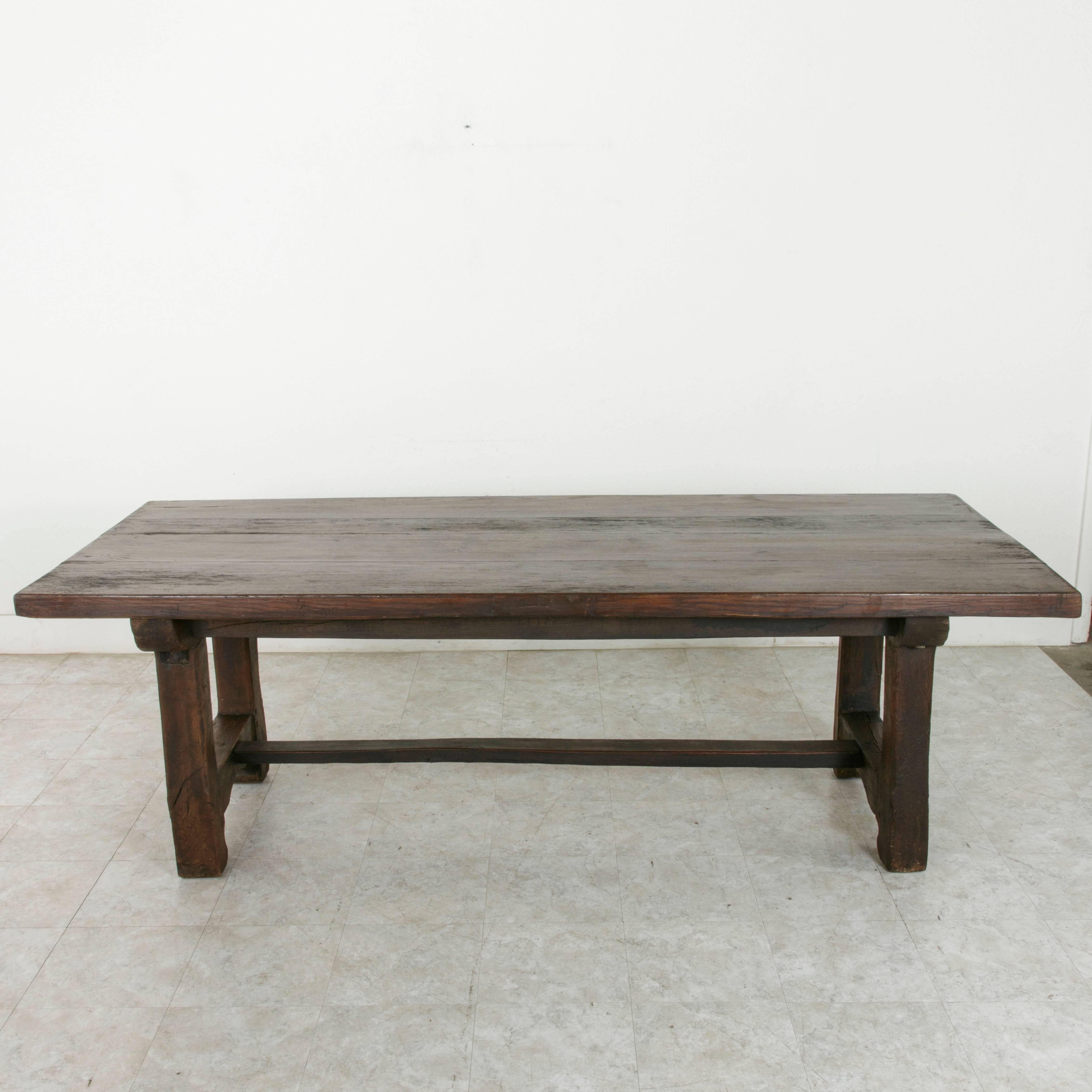 Created by 19th century artisans for a Normandy farm in France, this hand pegged oak trestle table was constructed using eighteenth century beams and mortise and tenon joinery. Its 2.25 inch thick top is formed by four planks of solid oak joined by