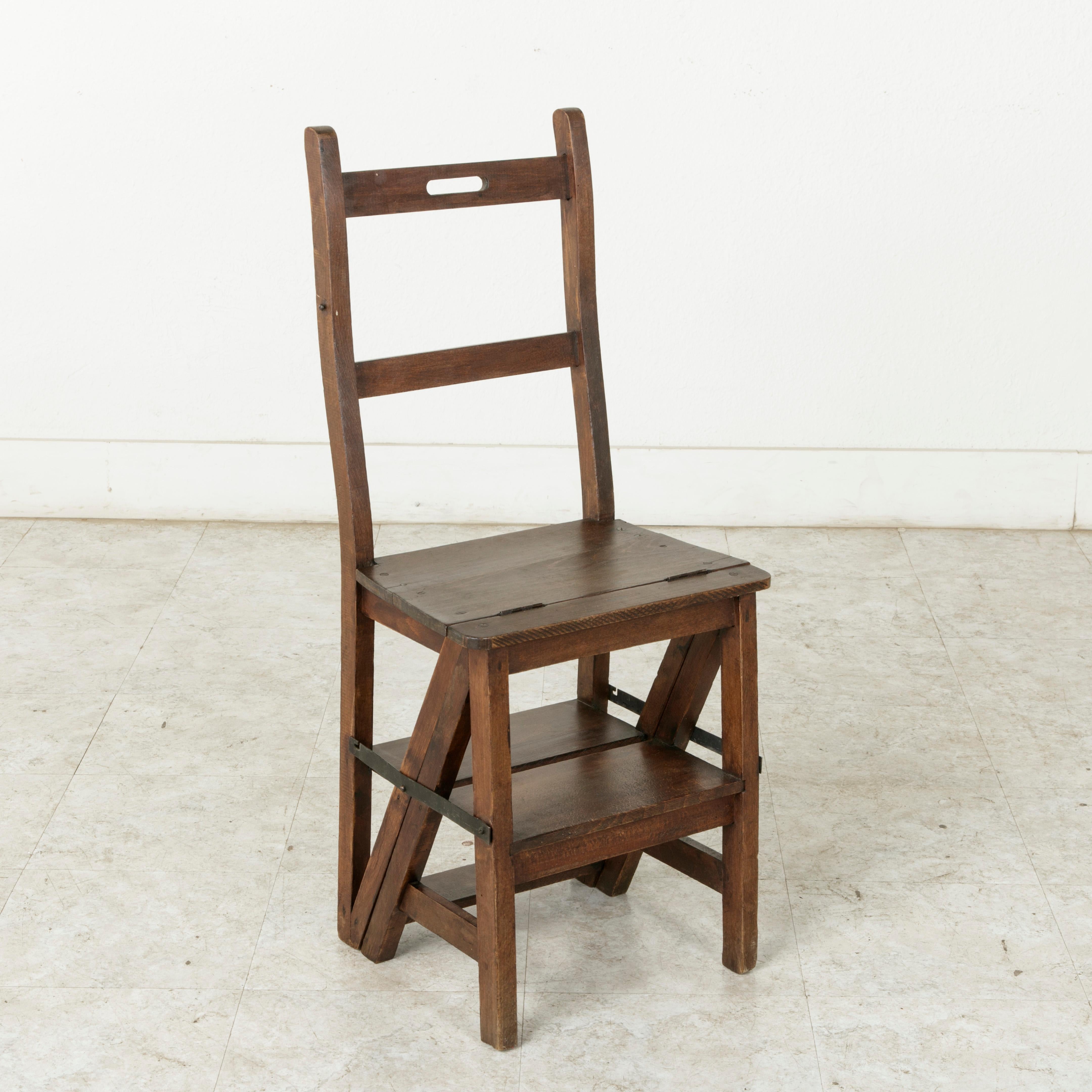 Dieser handwerklich gefertigte Klappstuhl aus Eichenholz stammt aus der südfranzösischen Provence und lässt sich mit einem Scharnier in eine Leiter verwandeln. Eisengurte mit Haken ermöglichen es:: das Stück sowohl als Stuhl als auch als Leiter zu