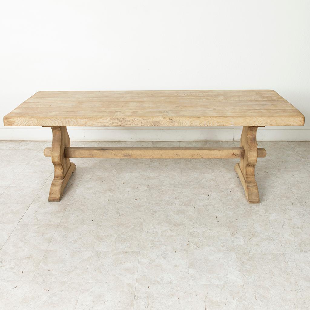 From the region of Normandy, France, this artisan-made oak monastery table or dining table from the turn of the twentieth century features a three-inch thick top constructed of six planks of wood. Resting on a sturdy trestle base constructed using