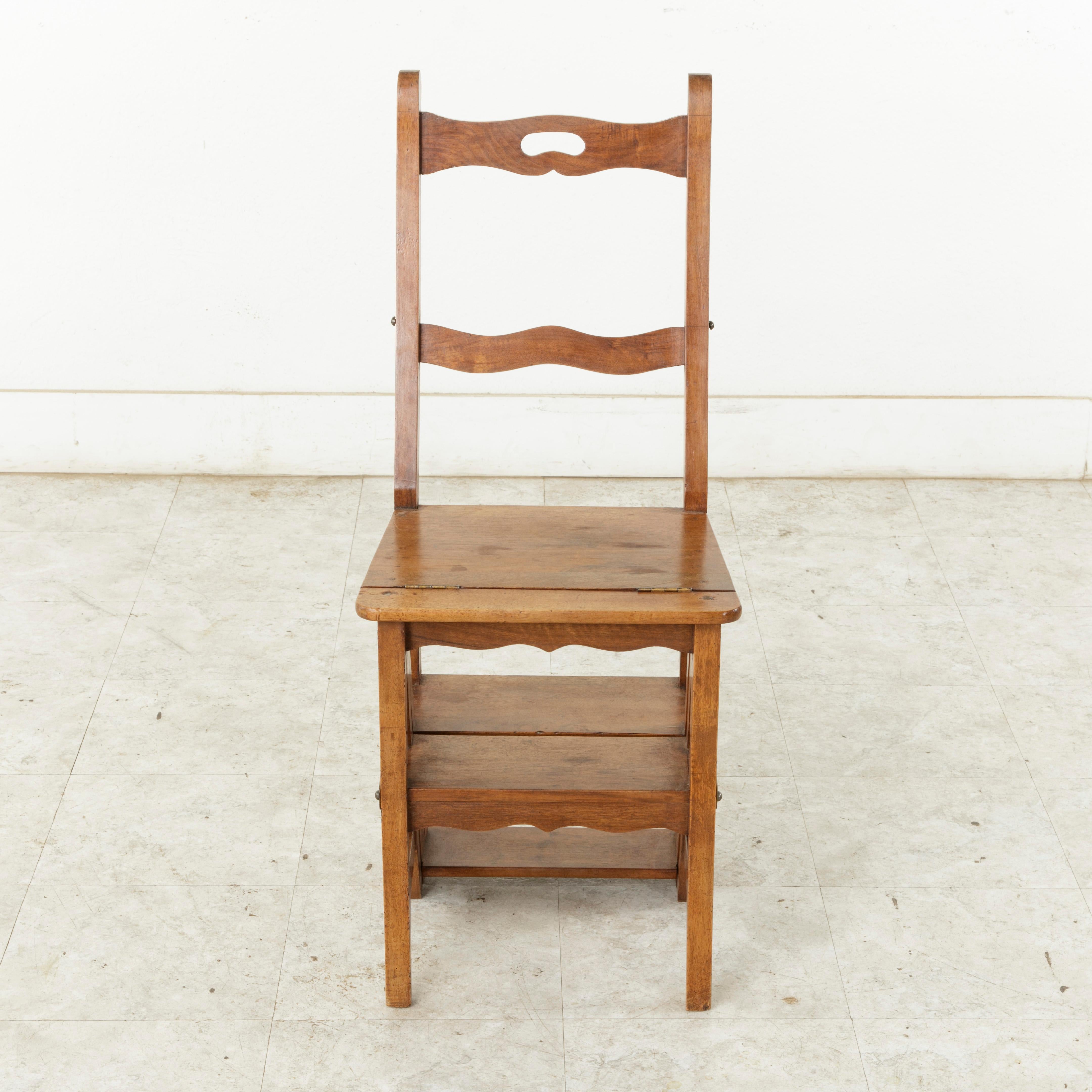 From the region of Provence in Southern France, this artisan-made walnut folding chair is hinged so that it can convert into a step ladder. Metal straps with hooks allow the piece to be secured in place both as a chair or ladder. When used as a