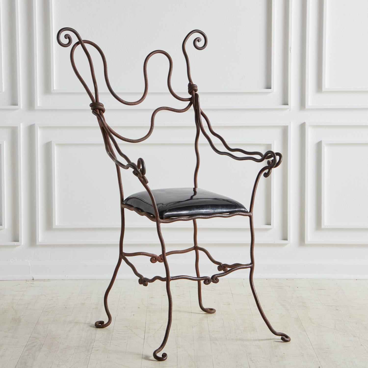 An artisan-made, wrought iron accent chair with a black vinyl upholstered seat. This sculptural chair is one of a kind and features astonishing craftsmanship. Sourced in France, 1950s.