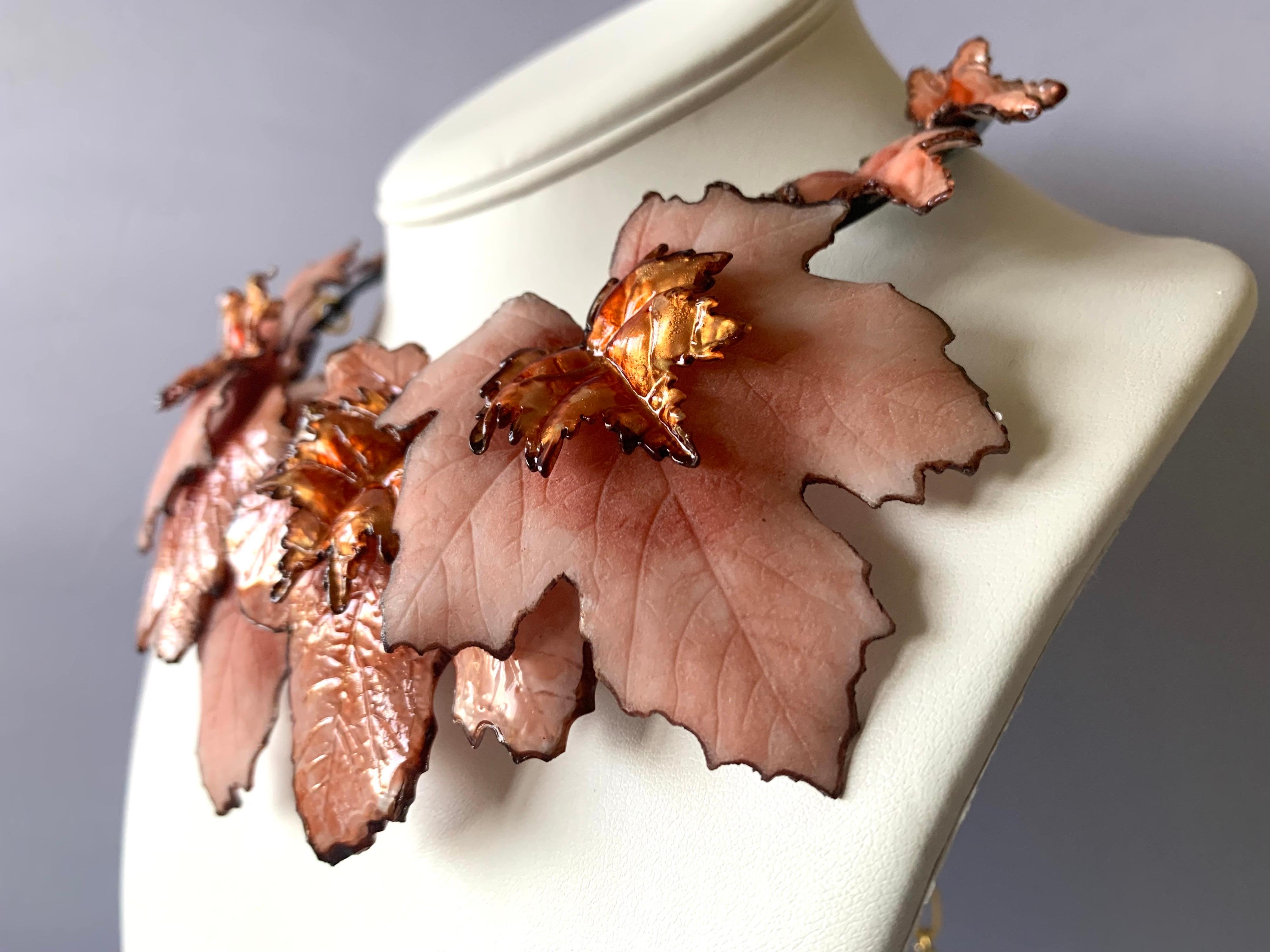 Contemporary artisanal statement necklace comprised out three-dimensional resin pink maple leaves - the leaves have metallic accents at the center giving the necklace depth and sophistication. Handcrafted in France by Cilea Paris.
