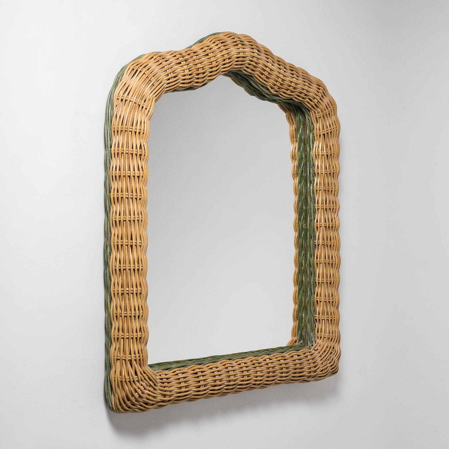 Unusually shaped French artisanal rattan mirror from the 1960s-early 1970s. Broad dual color rattan frame in very good original condition.