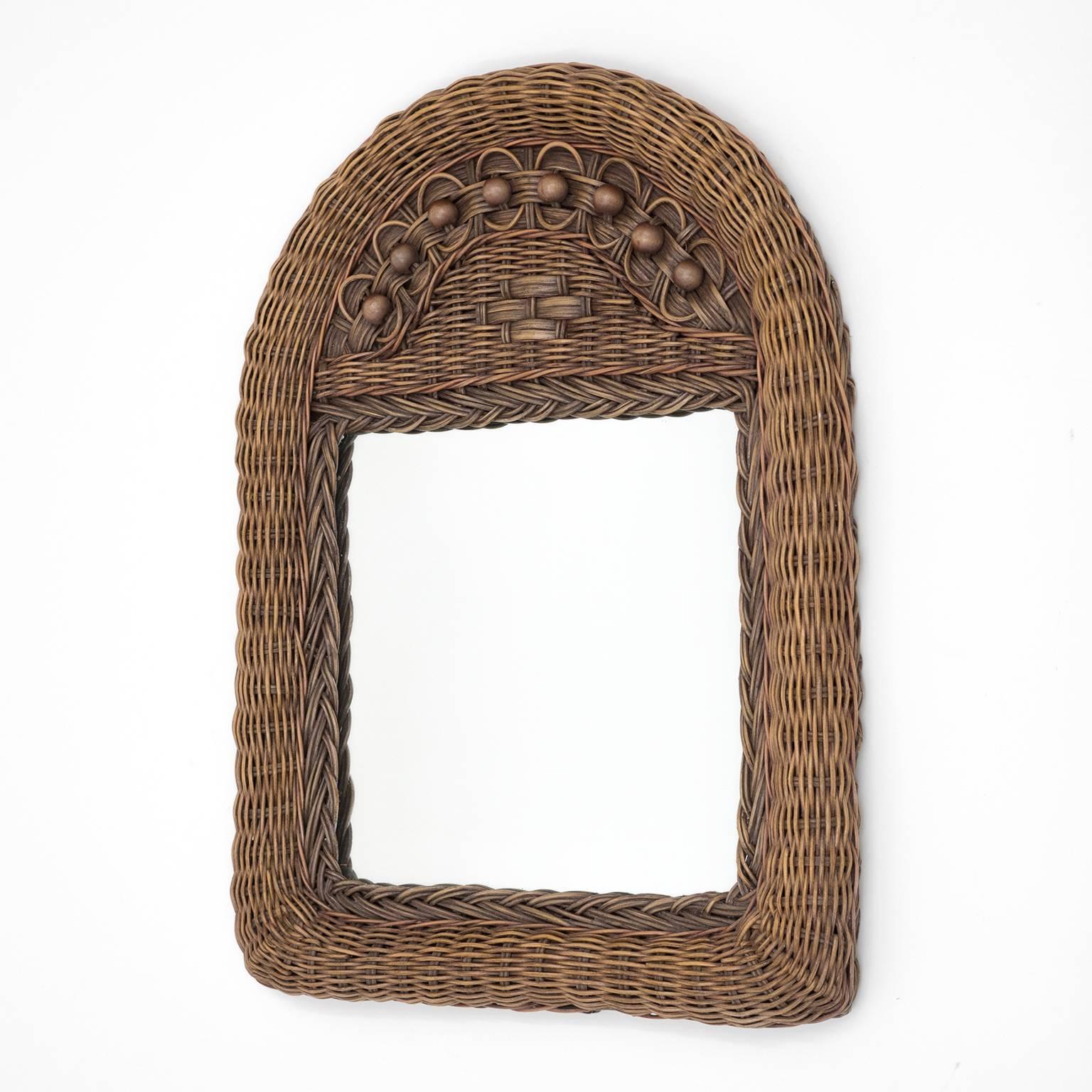 Lovely French artisanal wicker and rattan mirror from the 1960s. Very intricate craftmanship with different hued rattan elements and wood pearl details combined with different weaving patterns. Fine original condition with a touch of