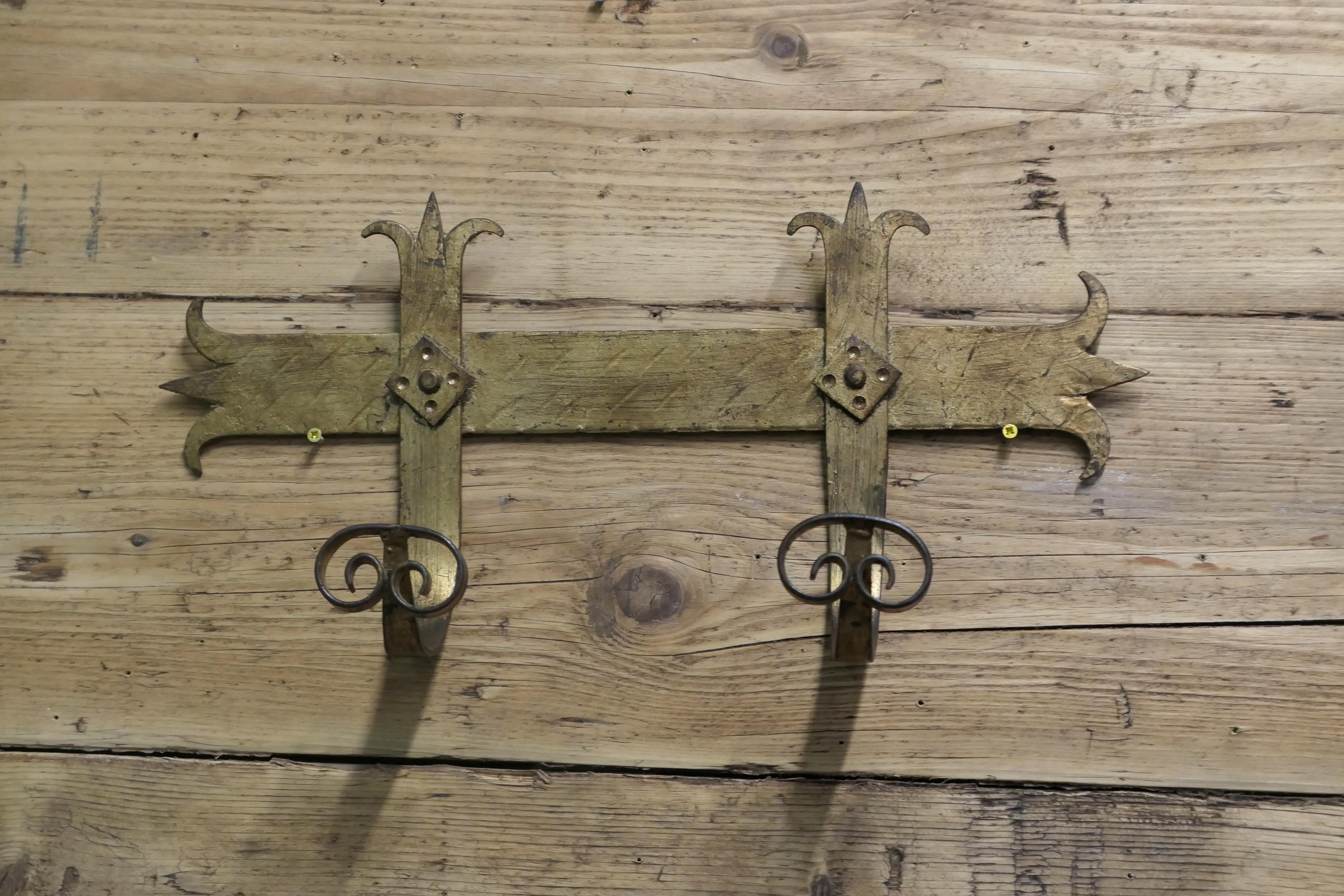 French Arts and Crafts Gothic Style Coat Hooks

Hand Made in Iron with a gilt finish, the Coat Rack
has 2 large curving coat hooks
The bracket is 9” tall, 19” long and stands out 5” from the wall 
WE253