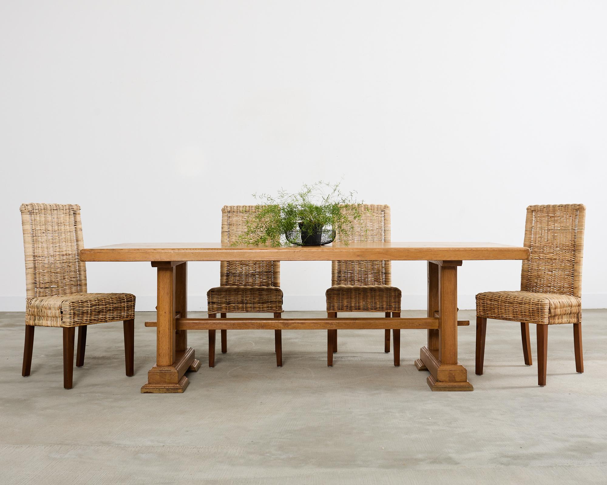 Sculptural mid-century French farmhouse trestle dining table designed with an arts and crafts style influence. Constructed from solid oak featuring a 2.5 inch thick rectangular top. The top is supported by a trestle base with large square shaped