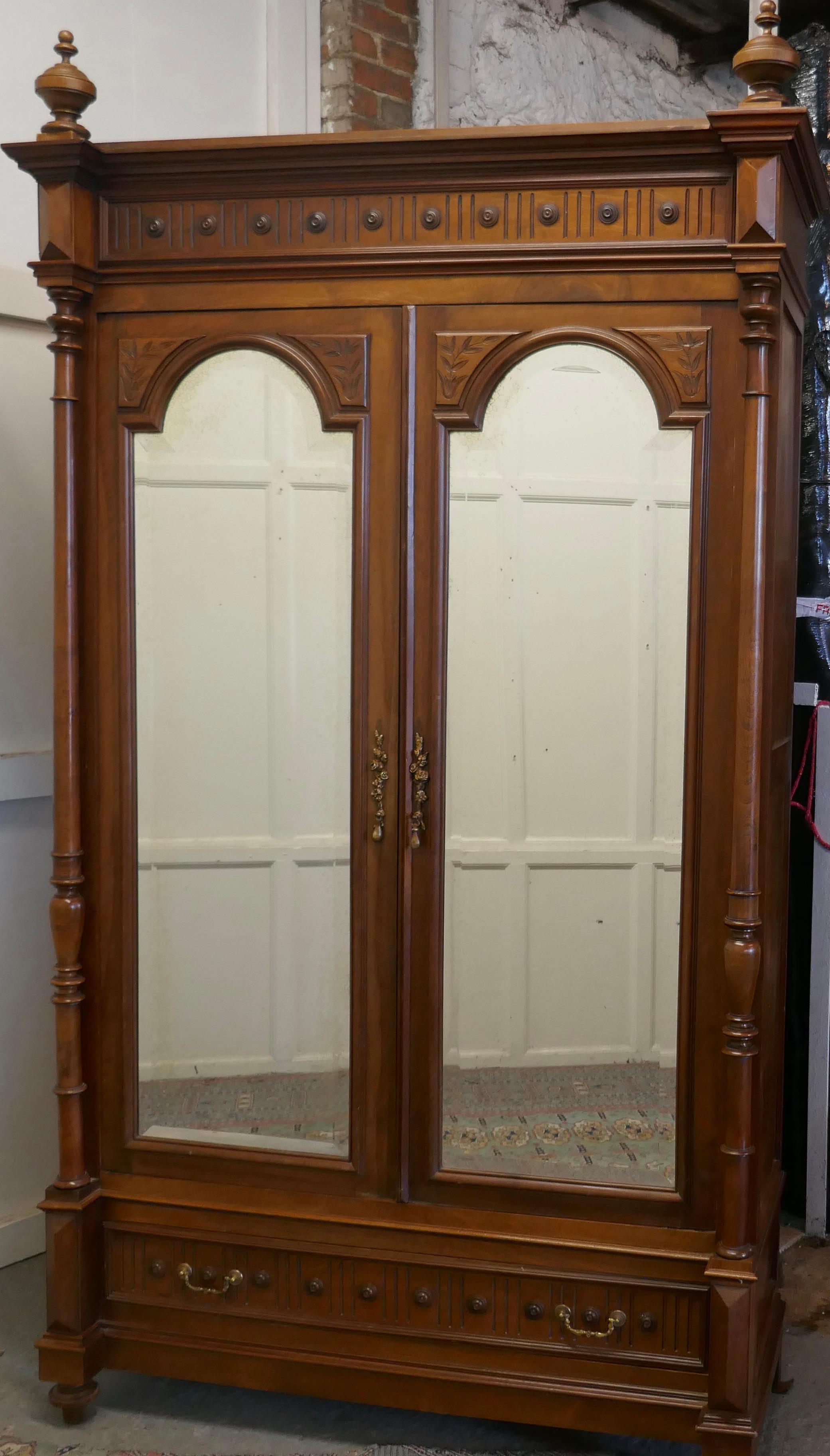 French Arts & Crafts walnut mirror double door armoire 

This is a good quality tall piece not surprising as it is made in figured walnut and has 2 mirrored Doors with a drawer at the bottom, inside there is a tall storage shelf and a hanging rail
