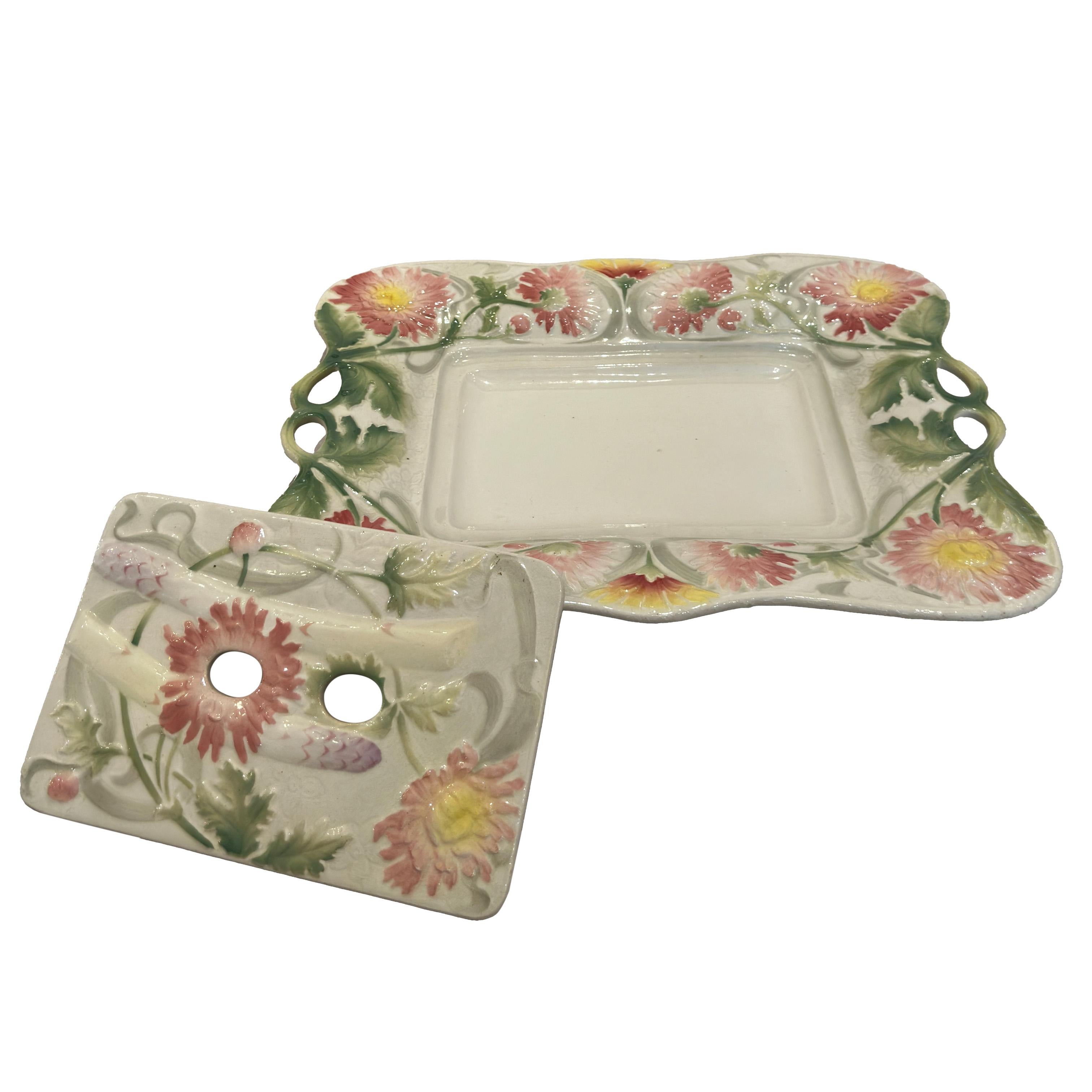 Découvrez une pièce exquise de la faïence française du Mouvement esthétique : un plat à asperges de Keller & Guérin, St. Clément, vers 1890-1900, dans le style Art nouveau. Ce plat comporte un égouttoir central amovible, orné de fleurs et