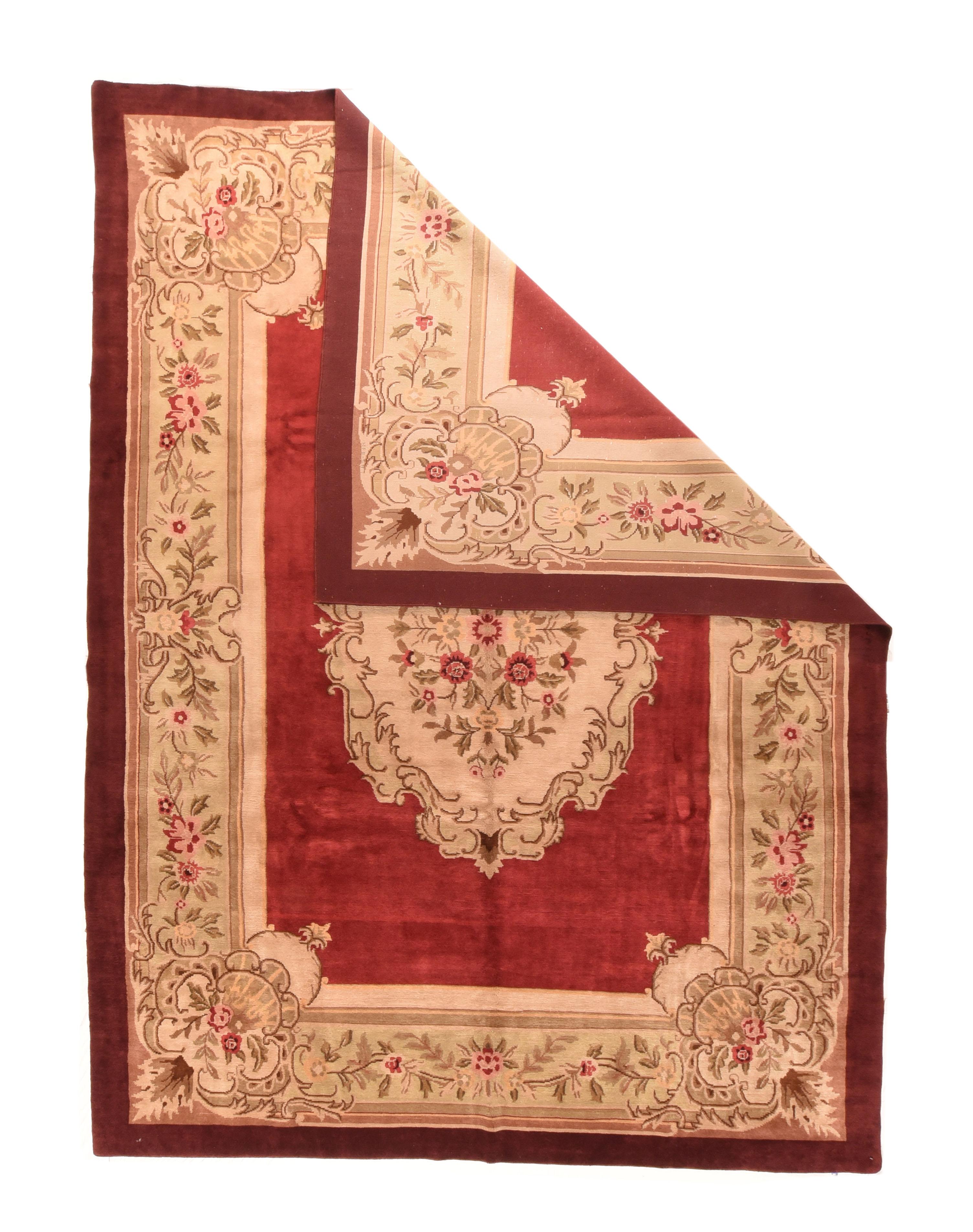 A rare, vintage French pile carpet from the famed Aubusson flatweave carpet workshops, this moderately woven piece shows a beveled red open field decorated by an oval ecru medallion with an acanthus leaf edge, and rosette and stem centre. Rococo