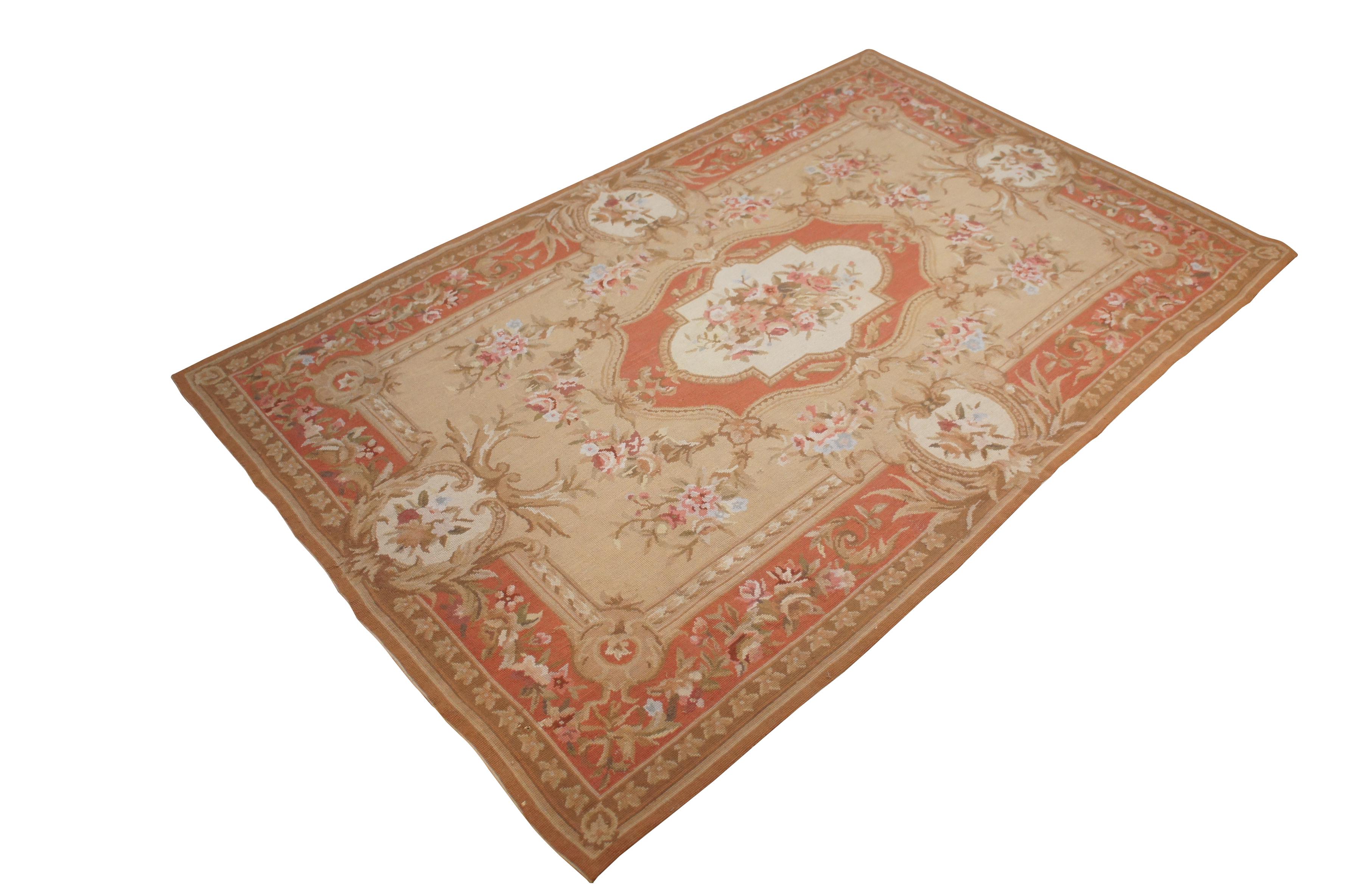 20th century hand embroidered French Aubusson needlepoint tapestry rug / carpet featuring a floral design of pink and blue flowers on concentric frames of peach / pink, beige, and cream.


Dimensions:
70
