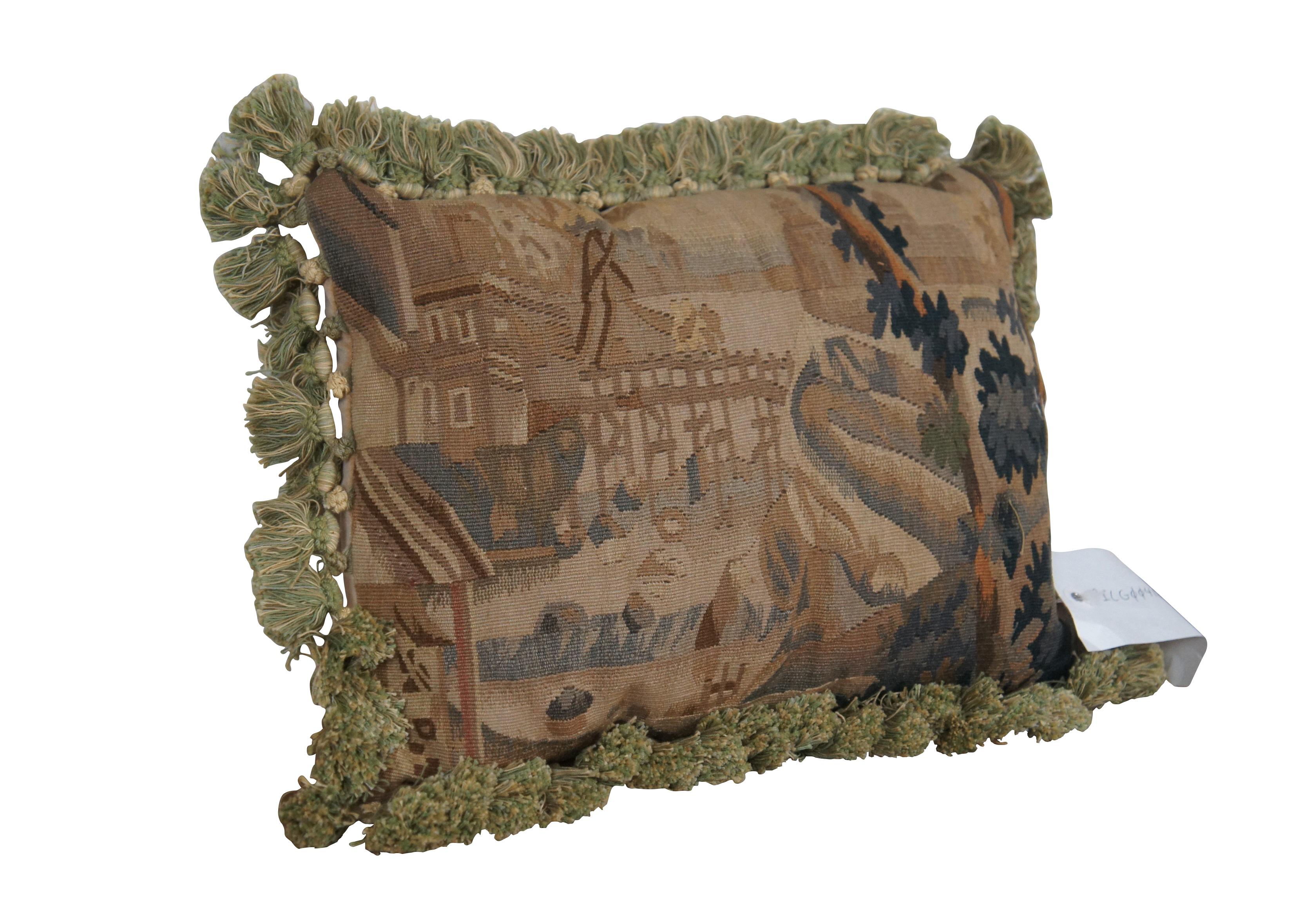 20th century French Aubusson style rectangular lumbar / throw pillow, embroidered in wool showing a cityscape along a river, framed with rocks and trees. Cream and green tassel trim. Light brown velour back with zipper closure. Down
