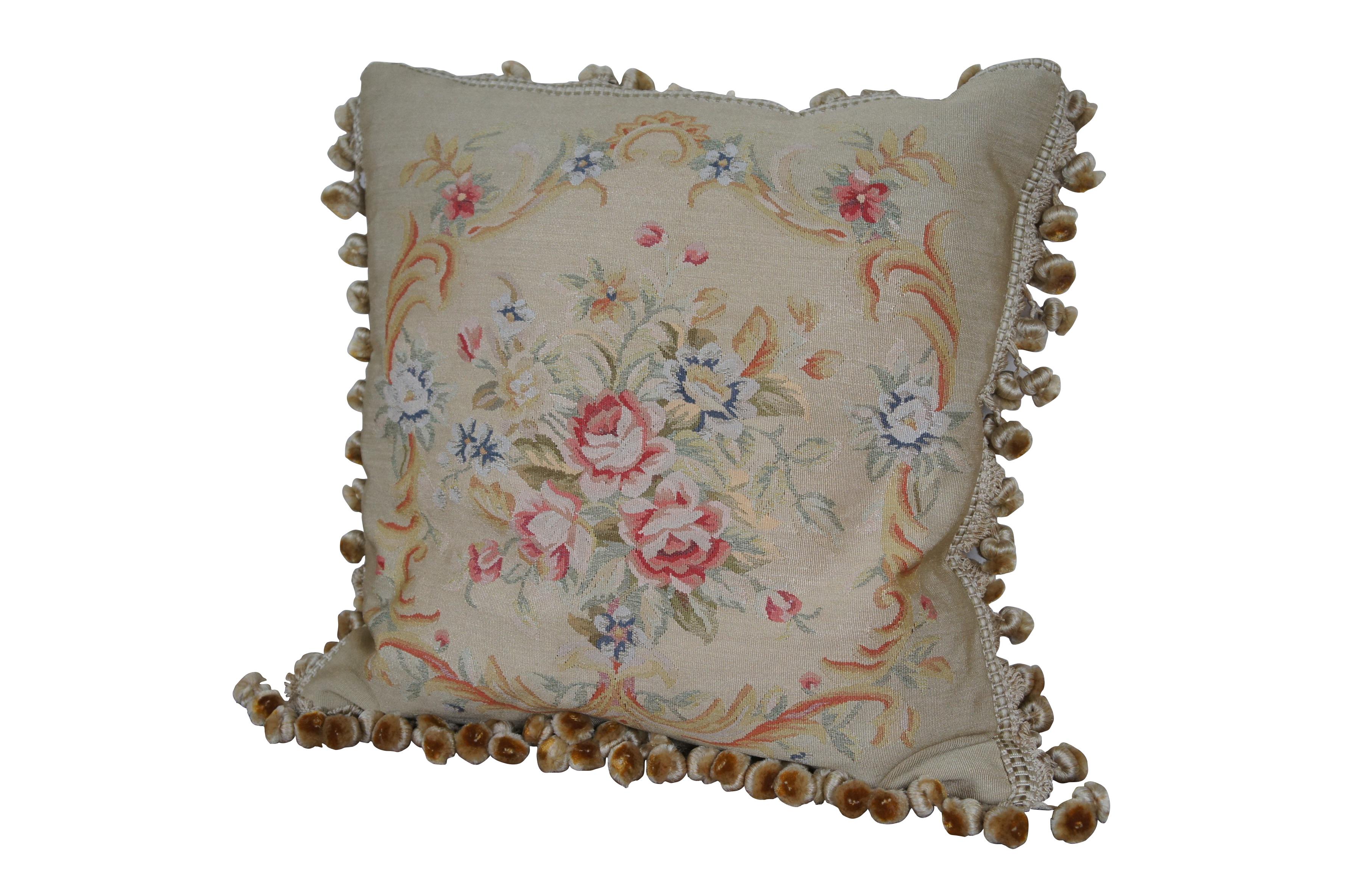 20th century square Aubusson style throw pillow, embroidered in silk with a bouquet of pink and blue flowers, surrounded by a swirling, golden, foliate frame. Cream ball tassel trim. Light brown velour back with zipper closure. Down filled. Made in