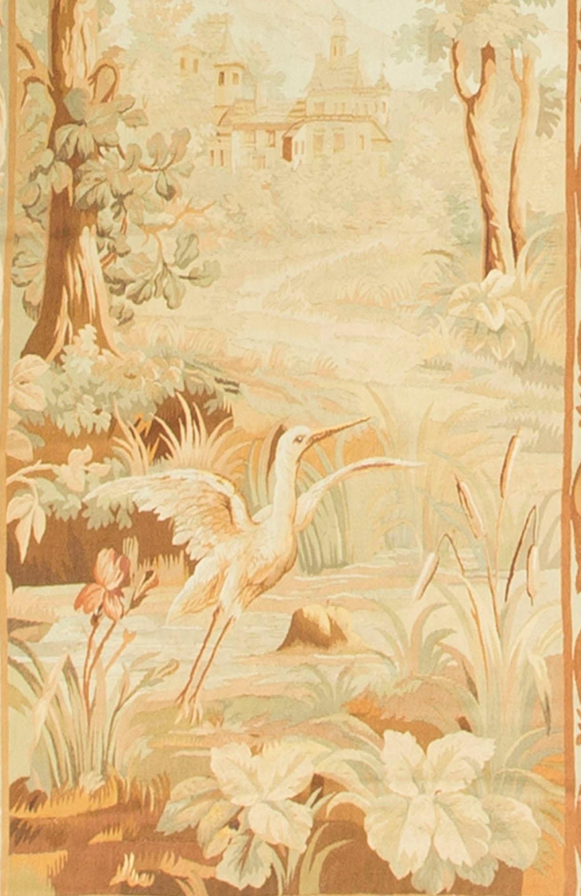 Un arazzo Aubusson del 1850 circa, dai colori tenui, raffigurante una tipica scena di campagna, con uccelli selvatici e alberi, con una casa di campagna sullo sfondo. Il tutto è circondato da un meraviglioso bordo floreale che raffigura un'ampia