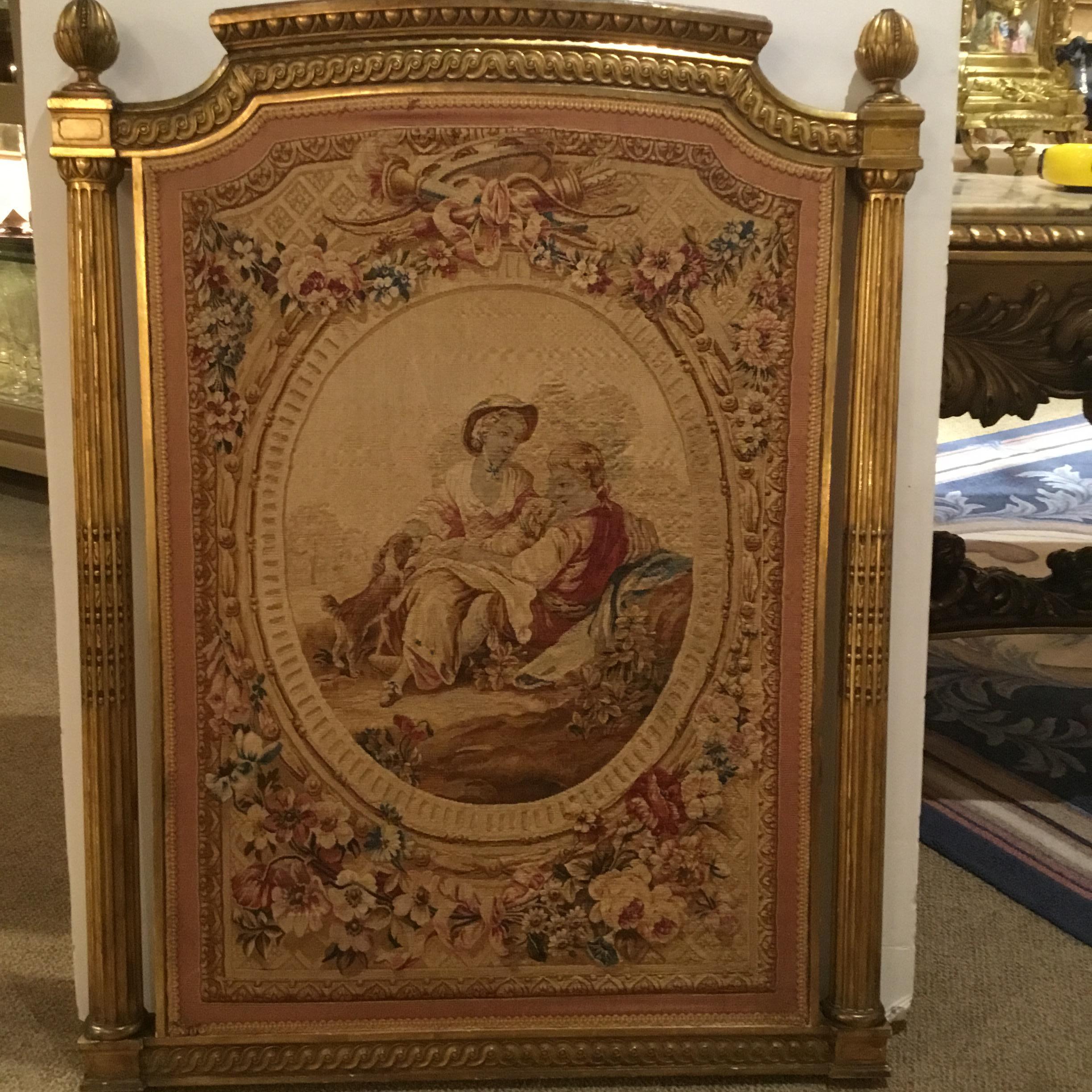 Louis XVI-Style giltwood frame with circular reeded columns on each side embellishes
This French Aubusson tapestry which depicts a romantic couple in a garden setting,
The scene is set in an oval cameo which is surrounded by flowers. A torch