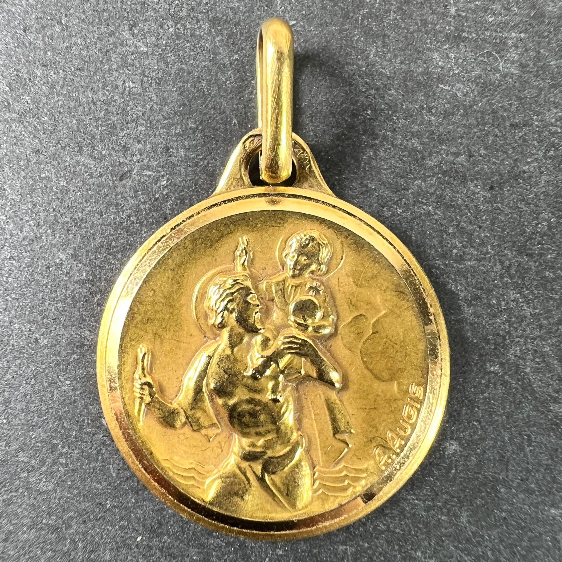 Colgante o medalla francesa de oro amarillo de 18 quilates (18K) diseñada por Augis que representa a San Cristóbal llevando a Cristo niño al otro lado del río. Esta inusual versión está modelada en altorrelieve con una fuerte sensación