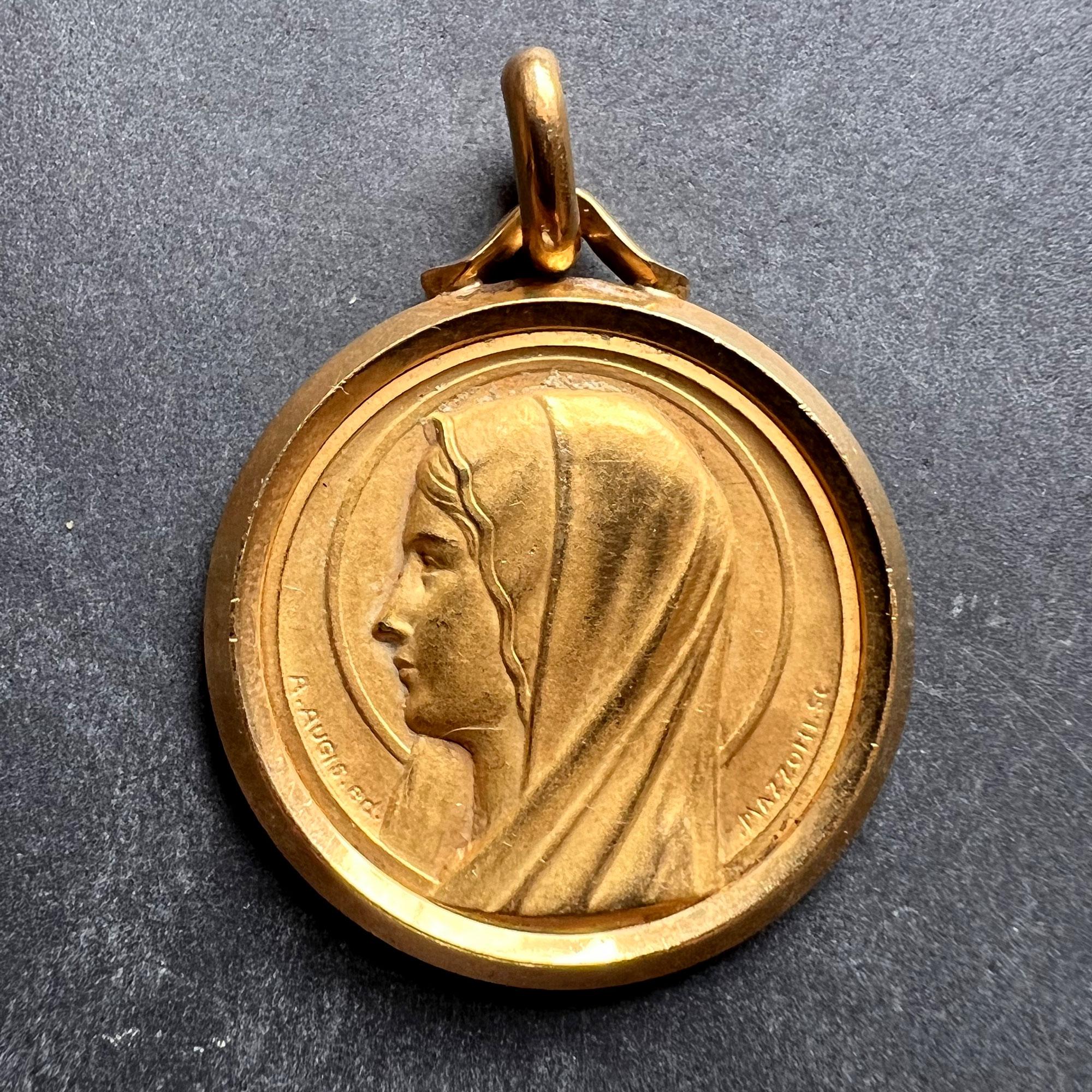 A French 18 karat (18K) yellow gold charm pendant depicting the Virgin Mary, signed A.Augis ED (made by) and Mazzoni SC (sculptor). Stamped with the eagles head for French manufacture and 18 karat gold with maker’s mark for Augis.

Dimensions: 2.9 x