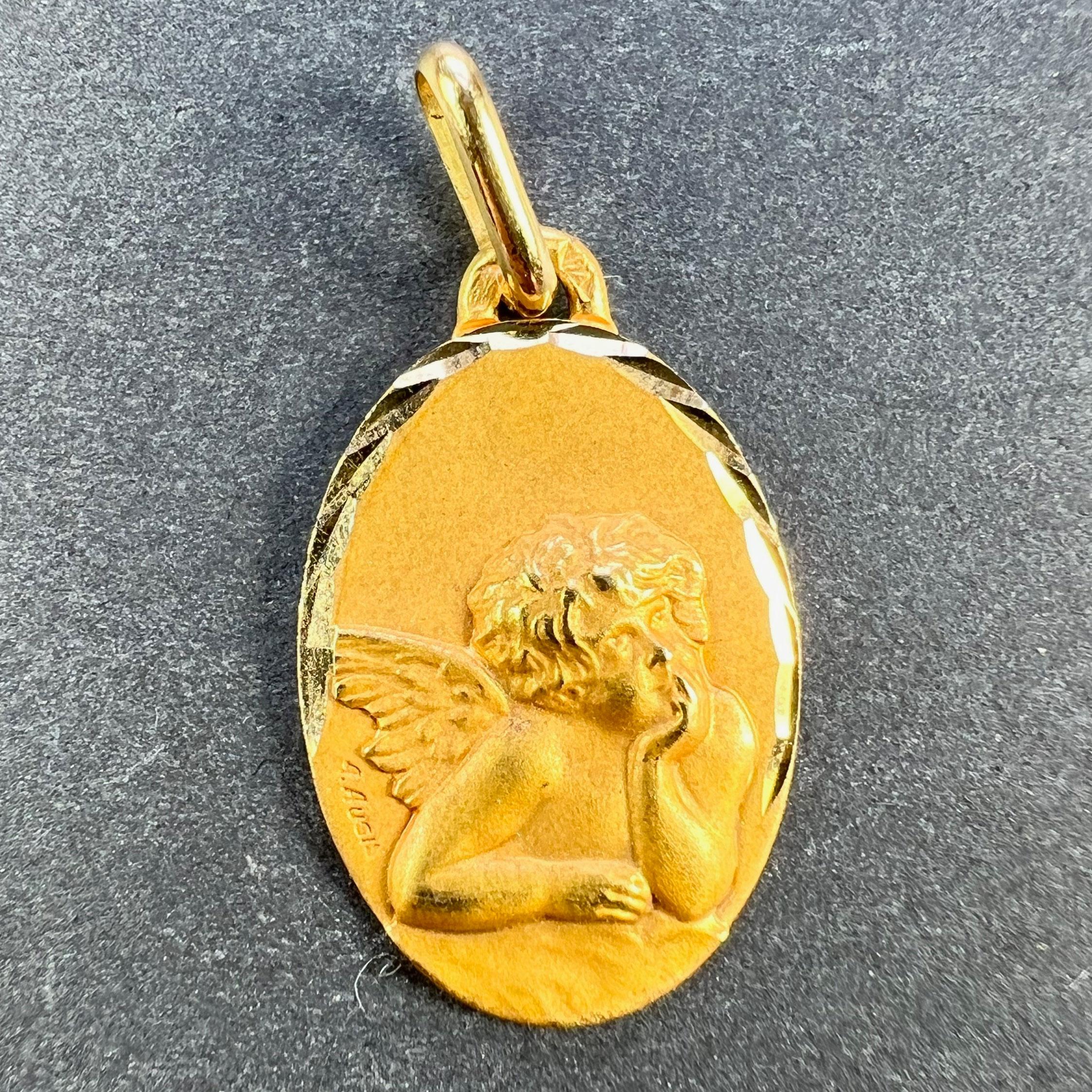 A French 18 karat (18K) yellow gold charm pendant designed as a oval medal depicting Raphael’s cherub. Signed A.Augis. Stamped with the eagle mark for 18 karat gold and French manufacture with an unknown maker's mark. The reverse marked A for