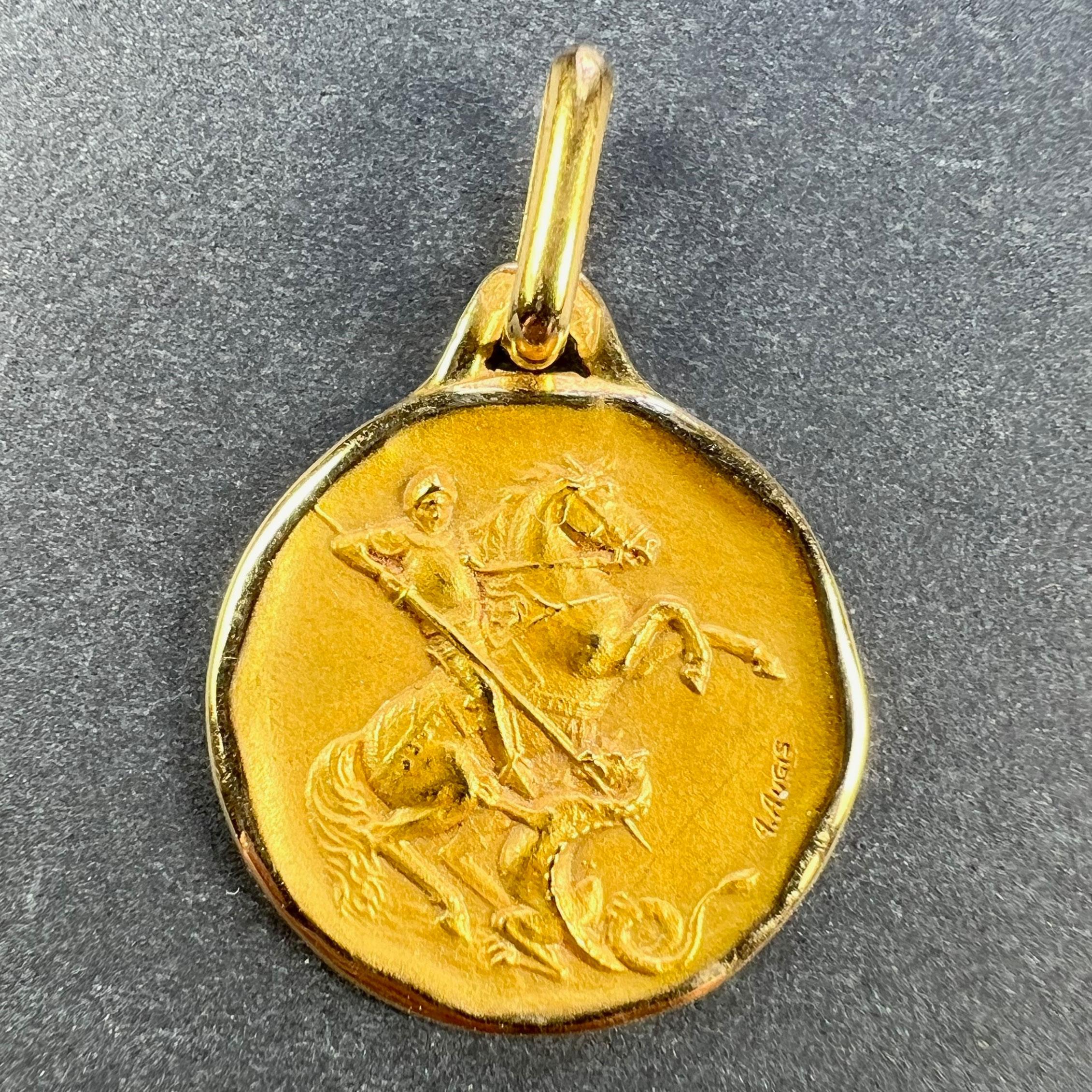 A French 18 karat (18K) yellow gold charm pendant designed as a medal depicting St George on a horse defeating the dragon. Signed A. Augis, stamped with the eagle's head for French manufacture and 18 karat gold with Augis's maker’s mark.