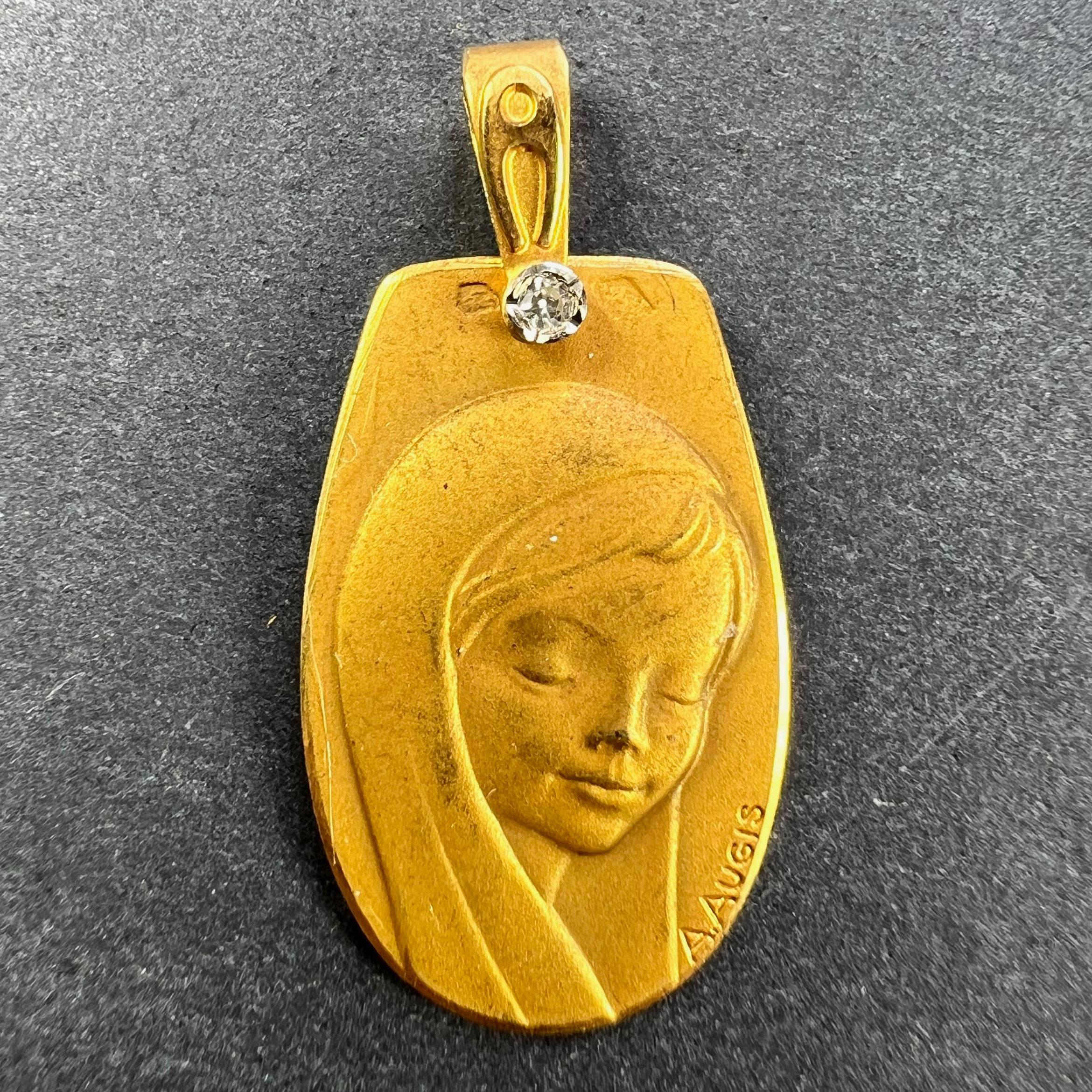 Colgante francés de oro amarillo de 18 quilates (18K) diseñado como una medalla ovalada que representa a la Virgen María engastada en la fianza del colgante con un diamante talla única de aproximadamente 0,05 quilates. Firmado A. Augis. Estampado