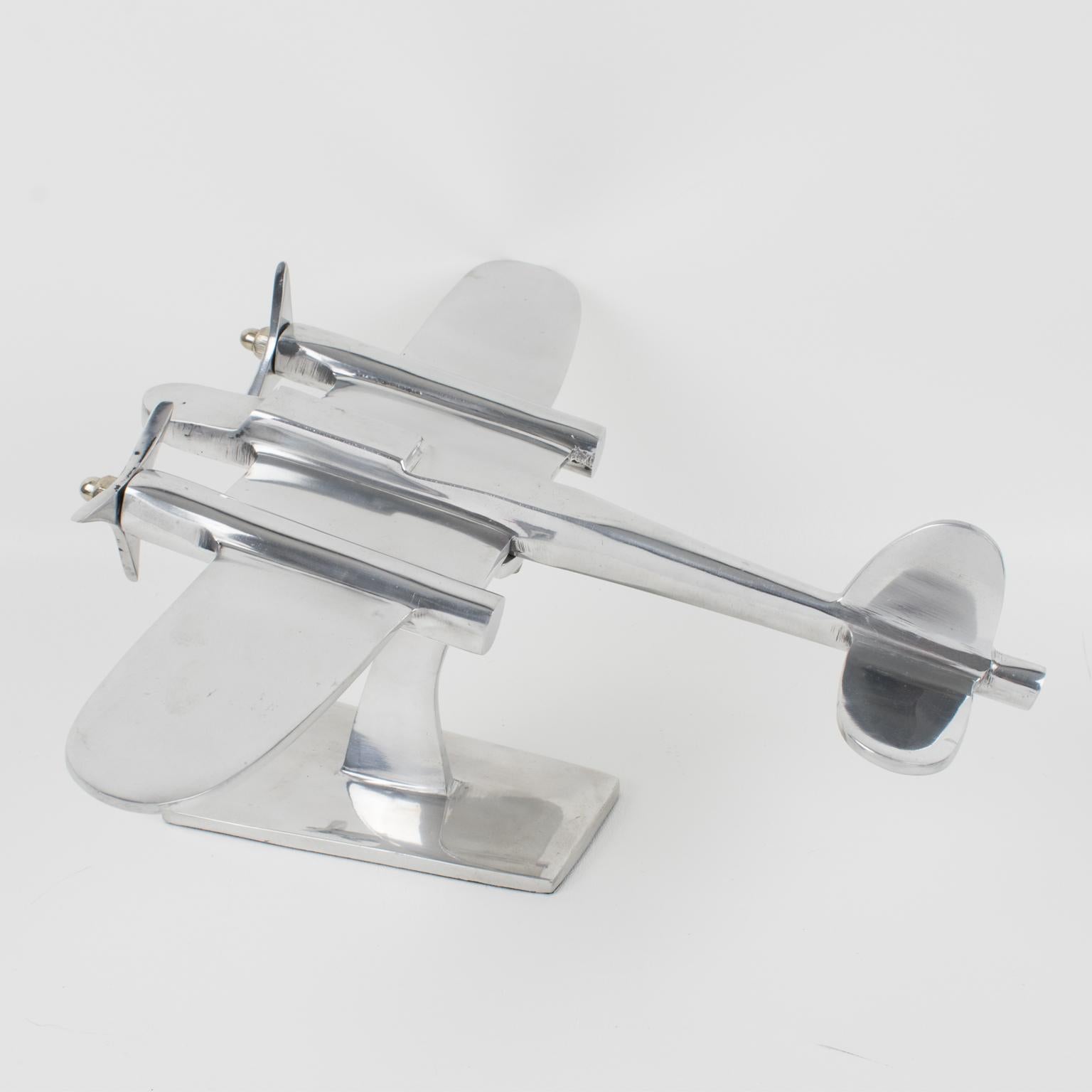 Elegant French aluminum airplane model mounted on a metal plinth. This nice sculptural model airplane is made with polished cast aluminum and has two original metal propellers. Standing on a geometric metal plinth with aluminum shaped arm. No