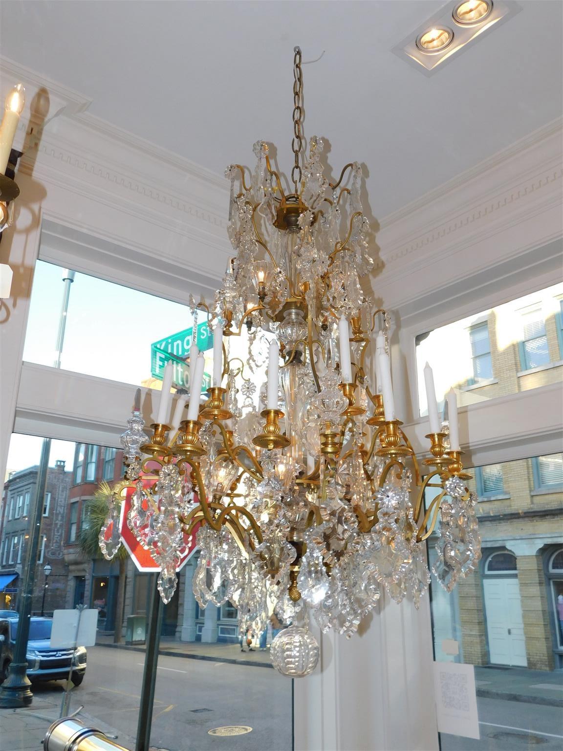 Lustre à bras articulés en bronze doré et cristal de Baccarat avec  Prismes de cristal à feuillage suspendu, colonne centrale de cristal cannelée et bulbeuse, bobèches à bougies cannelées en bronze doré, vases intérieurs en cristal cannelé