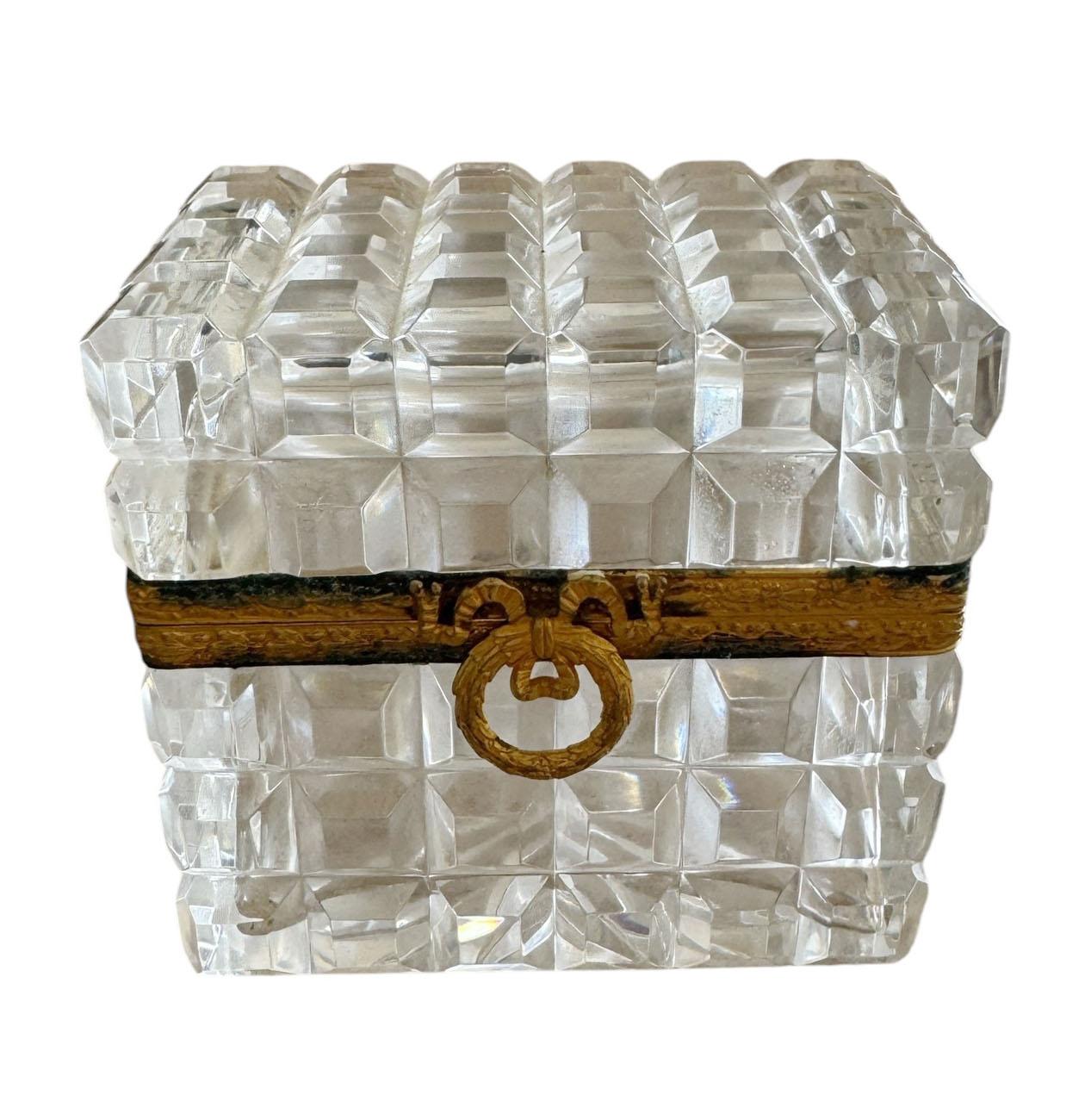 Un coffret en cristal français raffiné dans le style de Baccarat, fabriqué avec du cristal biseauté épais et lumineux et terminé par un fermoir en forme de couronne de laurier magnifiquement détaillé. Signée France et fabriquée exclusivement pour
