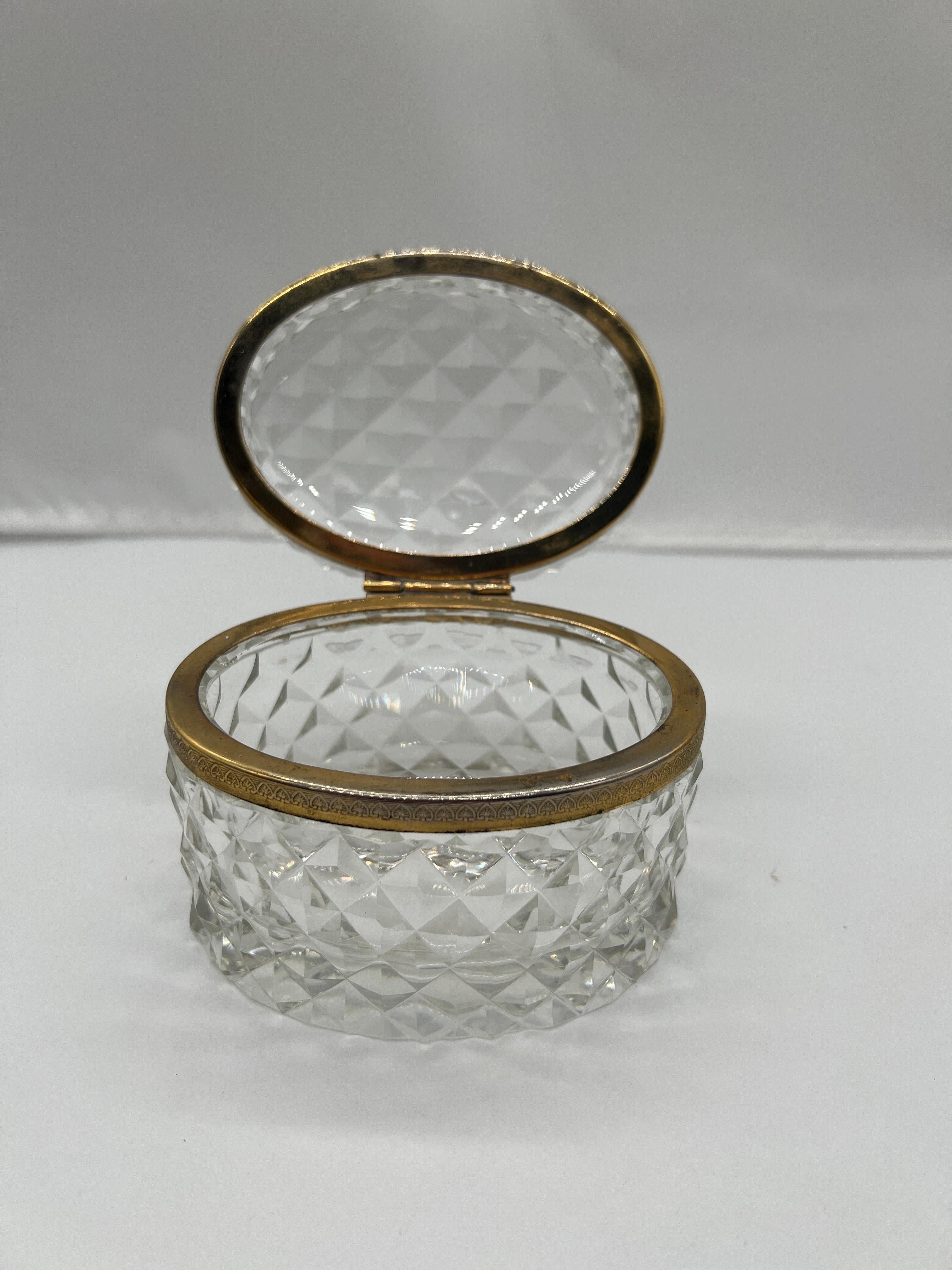 A wonderful early to mid 20th century crystal faceted box or jewelry casket in the style of Baccarat. The piece has a brass ormolu mounted ring to the center which is hinged. 