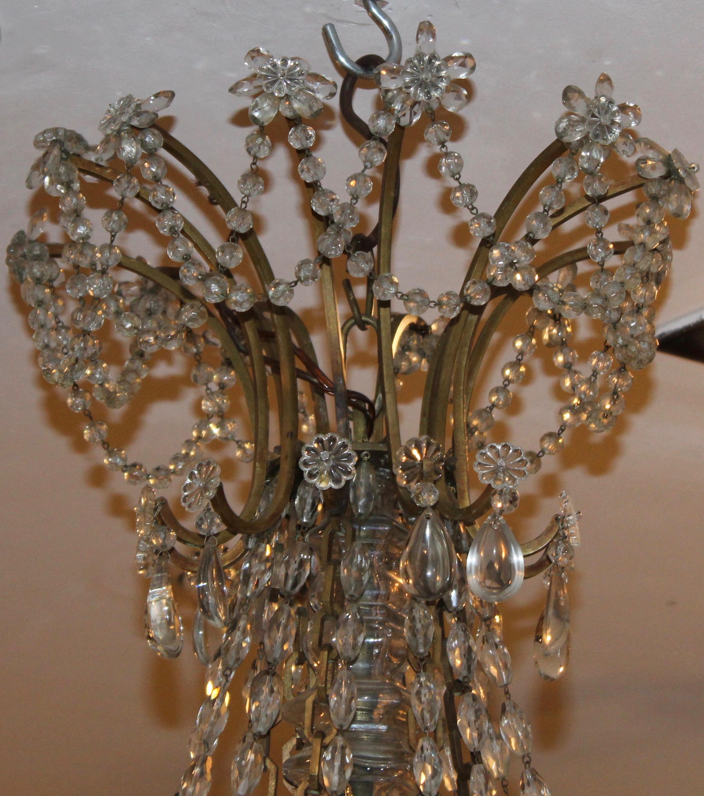 Exquisite French Baccarat style cut crystal drop chandelier, circa 1900. The simple bronze frame supports the twelve arms ad as well as the central crystal encased shaft , the chandelier features decorative metal chain that loosely connect the arms