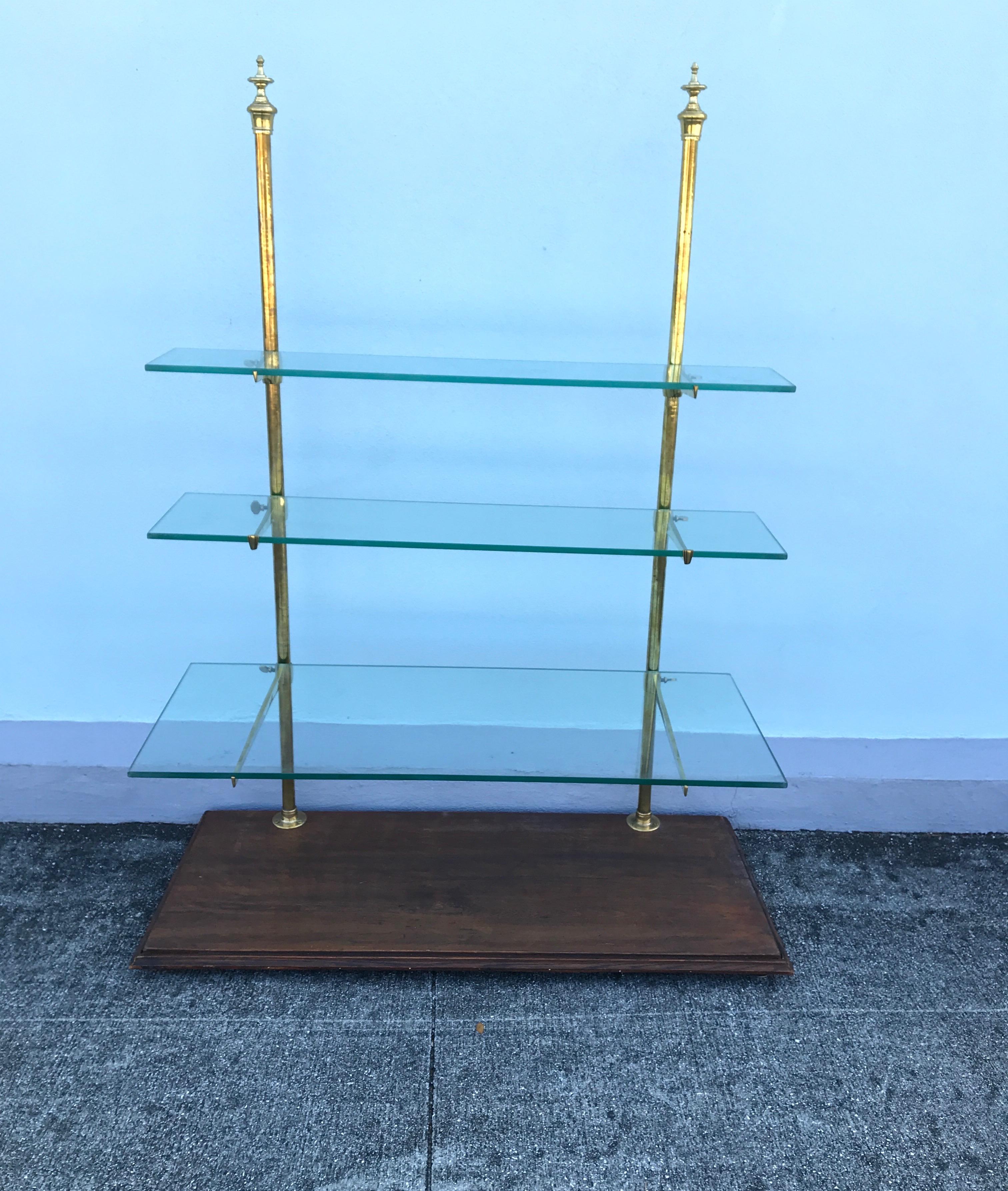 Antique French baker's display shelf with three graduated glass shelves with brass supports on a wooden platform. Shelves are 6