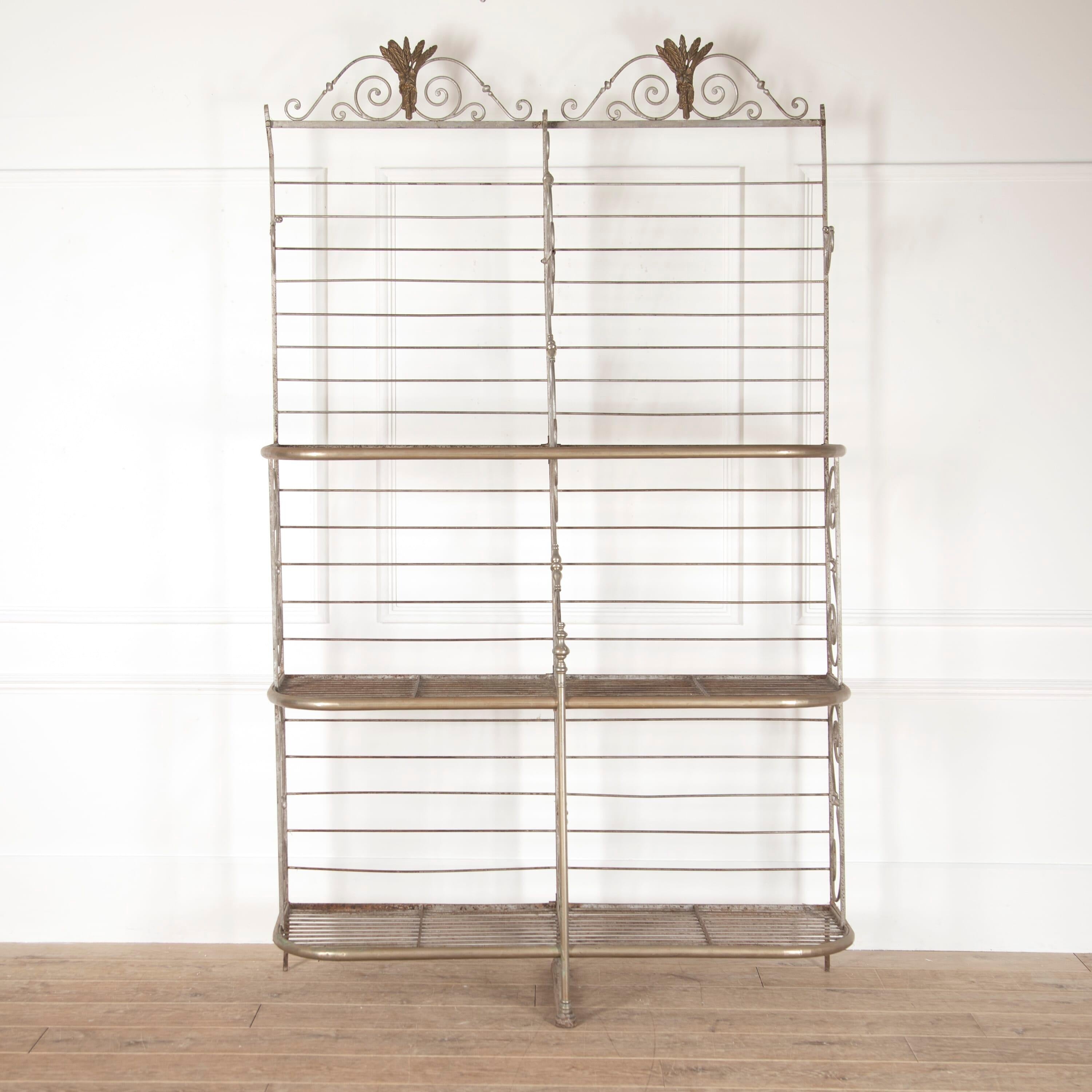 Wonderful French iron and brass-plated baker's rack, Circa 1930.

This highly decorative rack features double arches to the top, with plentiful scrolling forms throughout the frame. 

Offering three protruding racks, this baker's rack is both