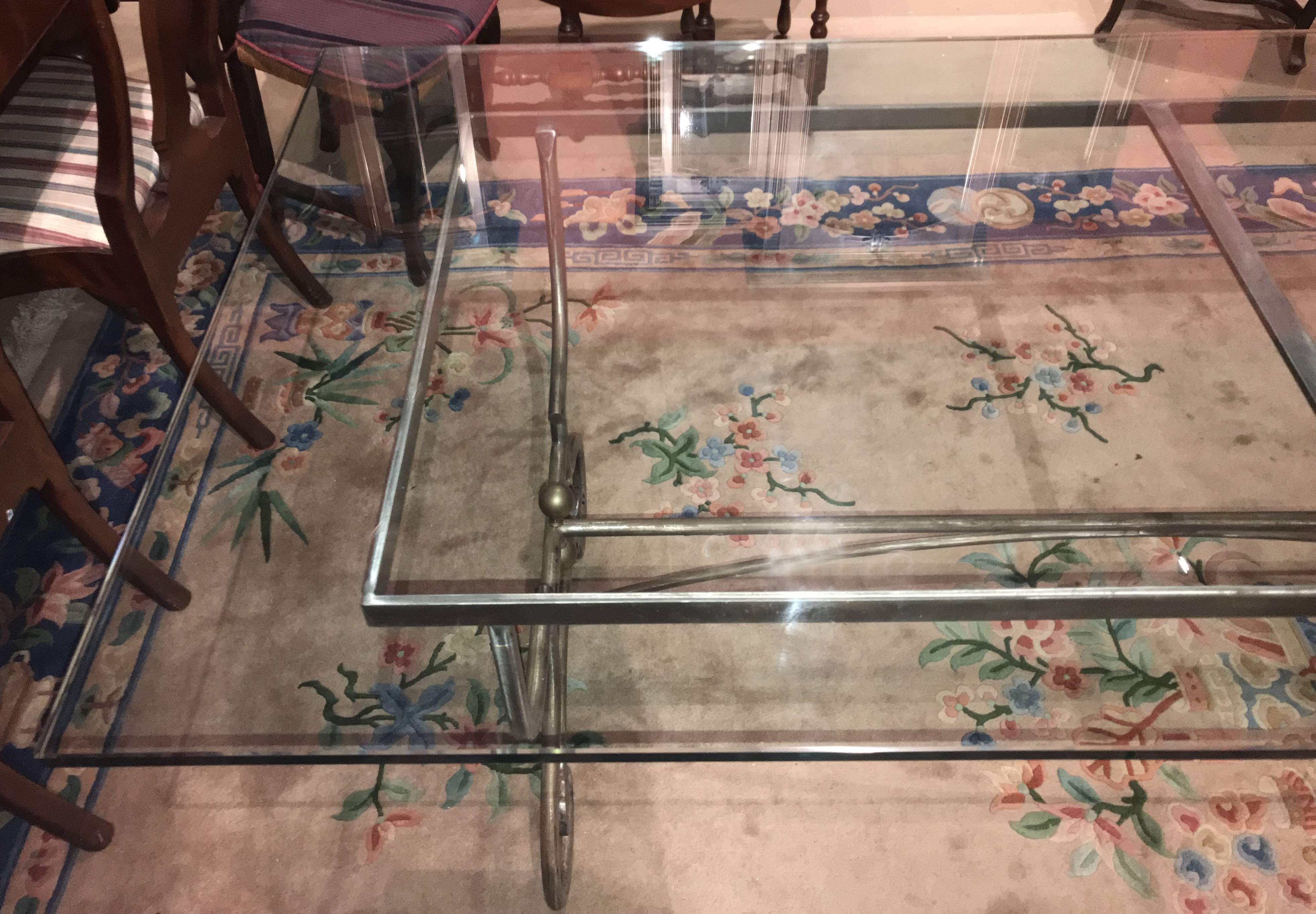 A wonderful adaptation of a French baker’s table iron base, married with a thick bevelled edge rectangular glass top to form a beautiful dining table or centre table, with scrolled legs, ball finials, and arched medial stretcher in a satin chromed